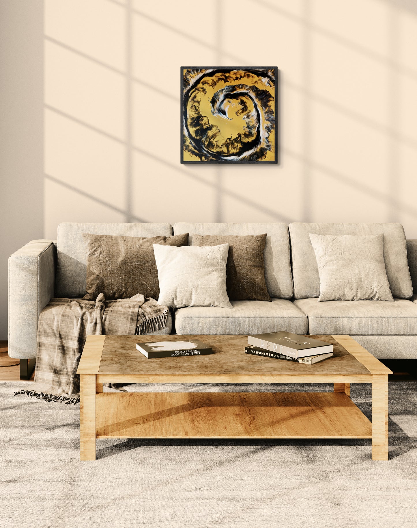 A square abstract painting in golden ochre, black, and white hangs above a light beige sofa in a sunlit room. The walls are soft tan, and the space is decorated with neutral pillows, a cozy throw blanket, and a light wood coffee table, creating a warm, rustic-modern living room atmosphere.