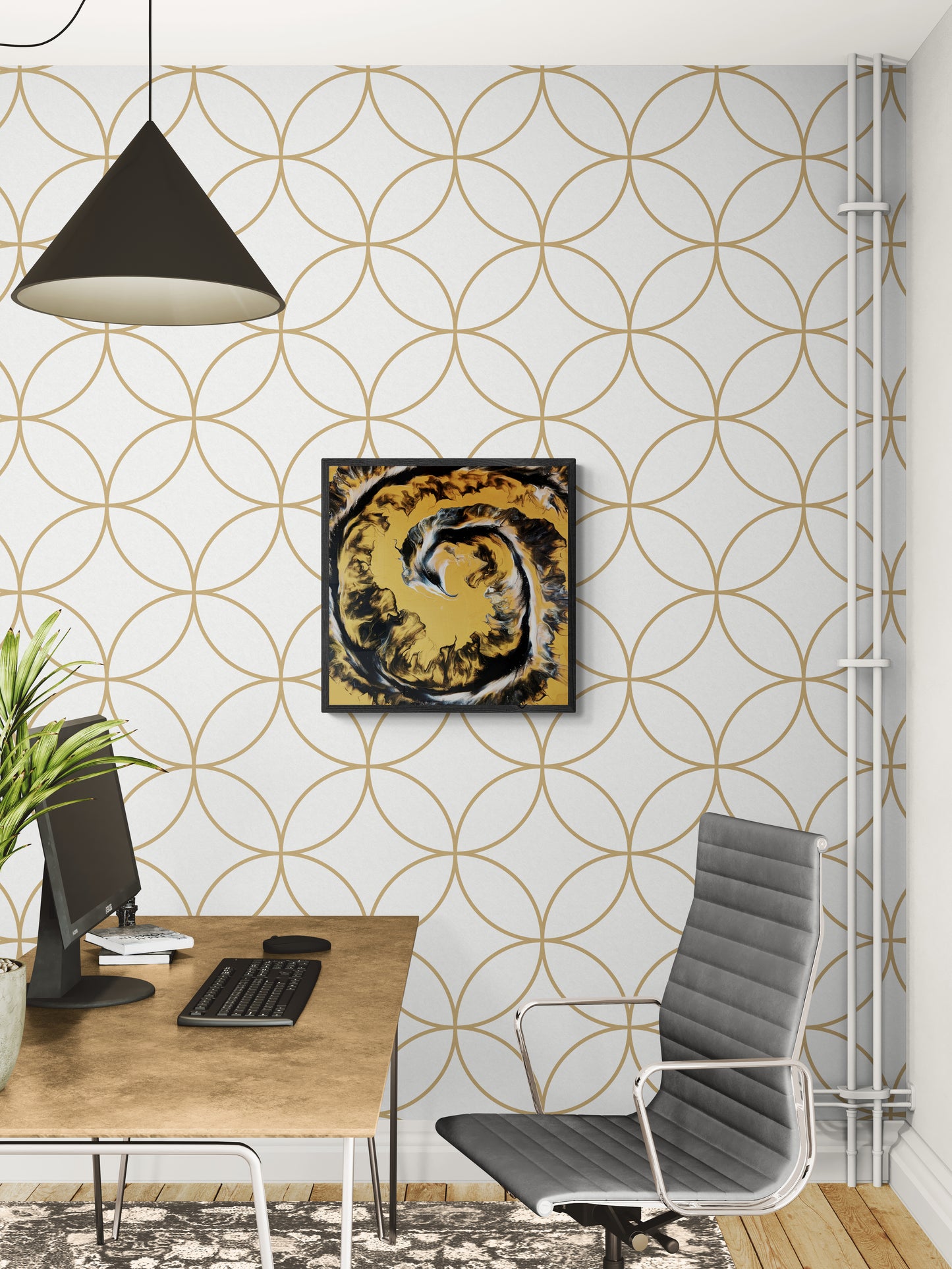 A bold, abstract painting with swirling black, white, and golden ochre tones hangs above a modern desk in a stylish home office. The wall features a repeating gold circle pattern on a white background, and the space includes a wood-toned desk, gray desk chair, and black pendant lamp, blending artistic energy with a functional, contemporary vibe.