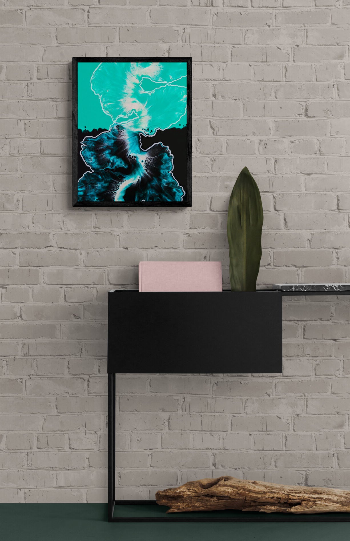 Between the Lines – framed teal and black fluid art print hung on a gray brick wall above a modern console with decor accents.