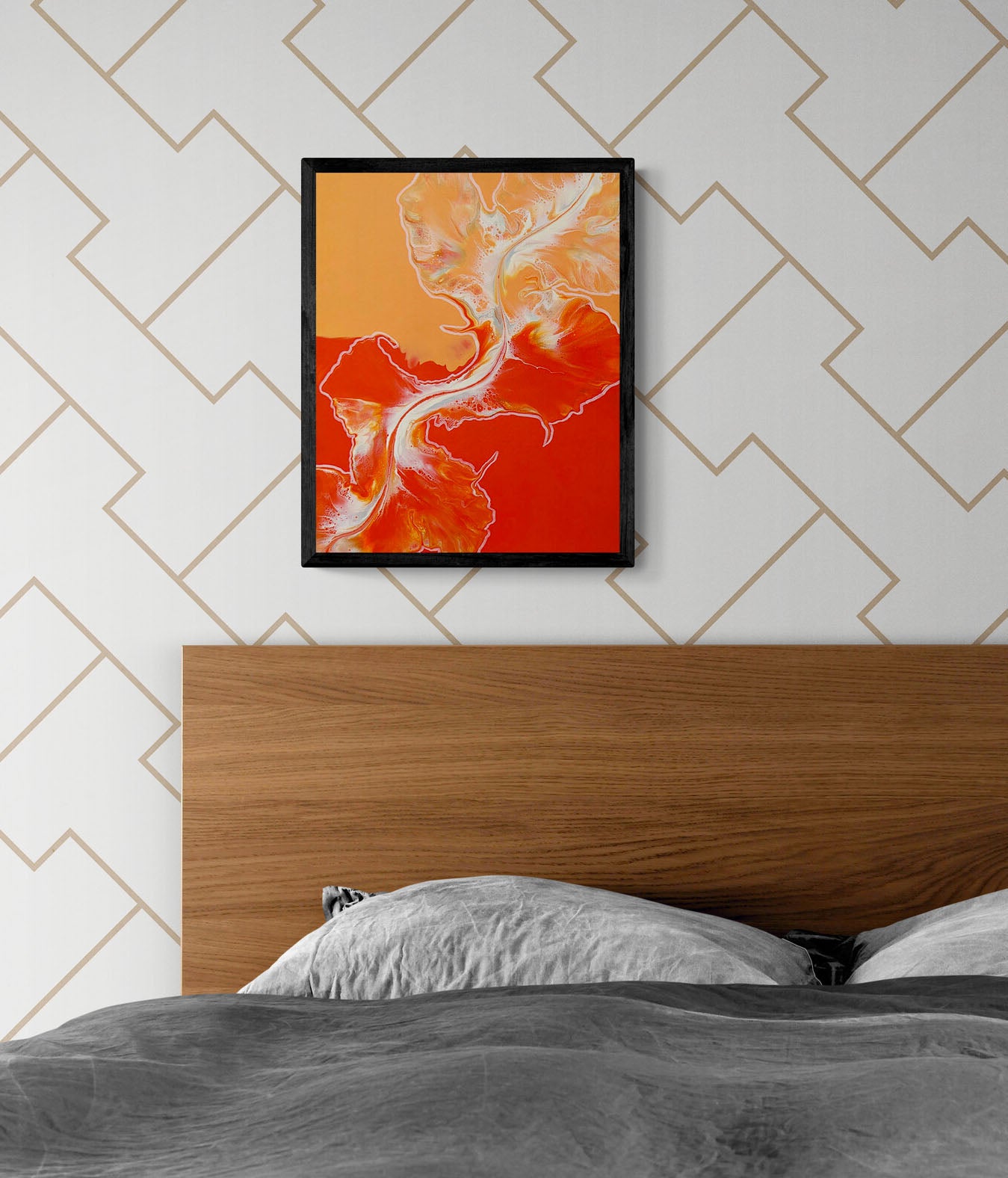 Framed acrylic fluid art print Cross the Line with fiery red, orange, and white abstract textures, hanging above a wooden bed frame in a modern bedroom with gray bedding.