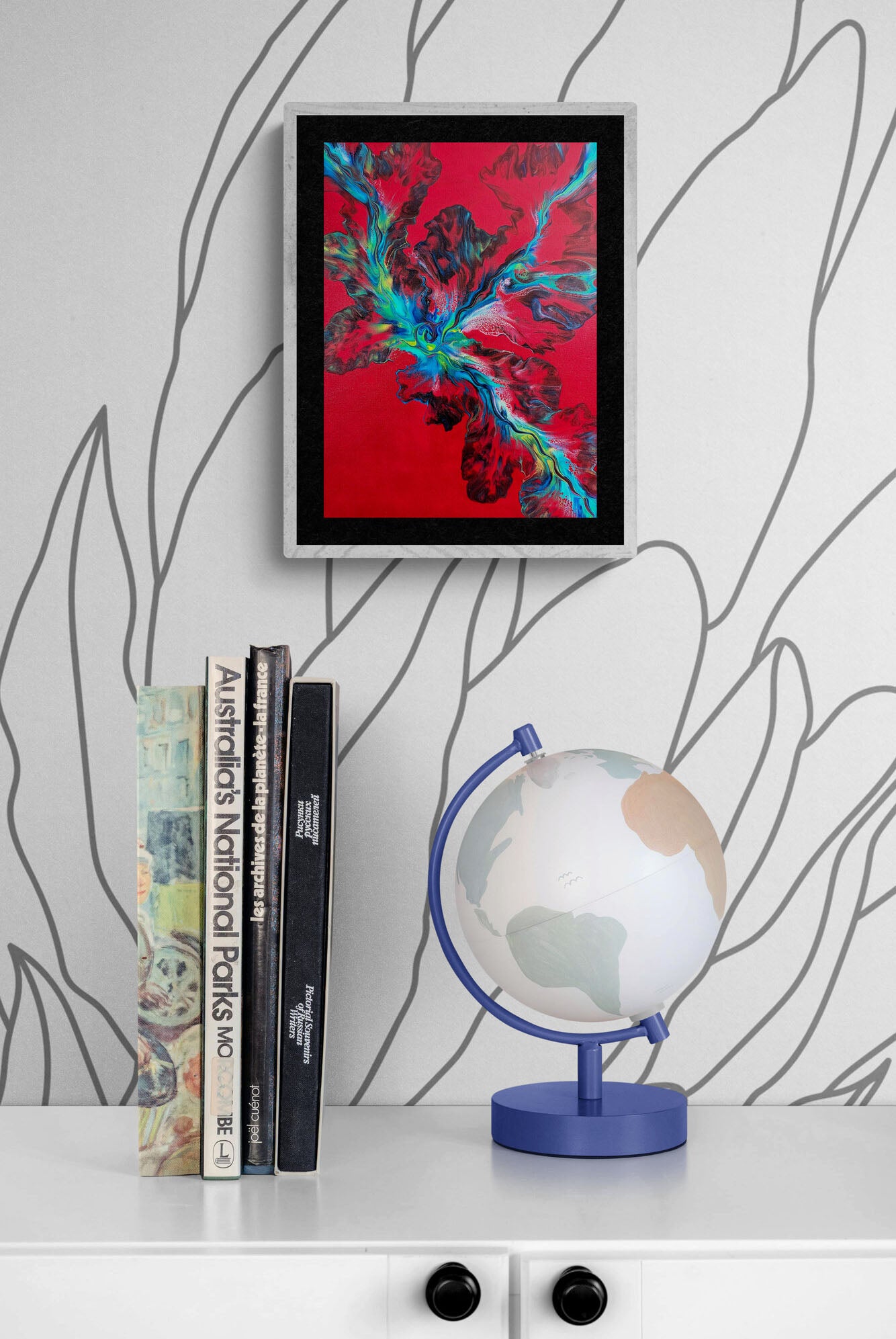 Elemental Surge – vibrant red abstract fluid art print with blue and green accents, framed wall decor displayed above books and a modern globe.