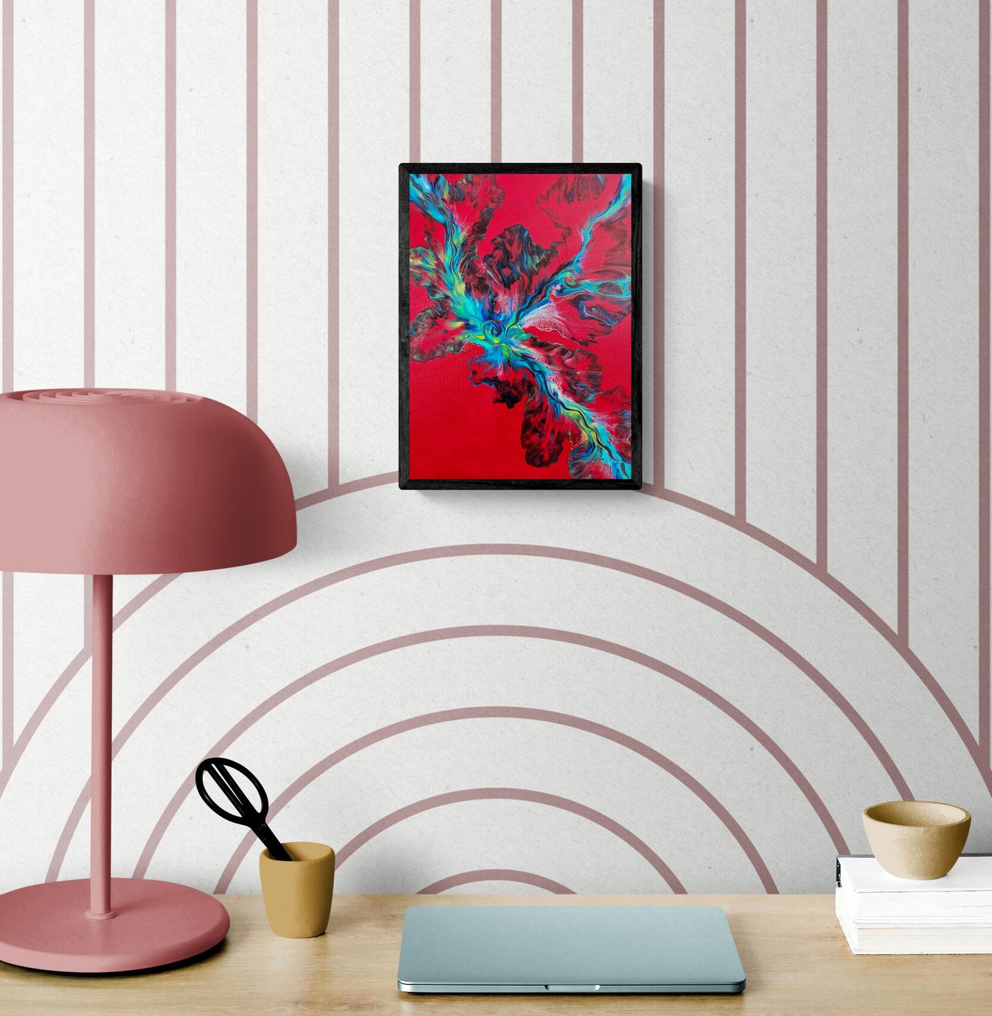 Elemental Surge – abstract fluid art print in bold red, blue, and green tones, framed wall art styled above a modern desk with pink lamp and laptop