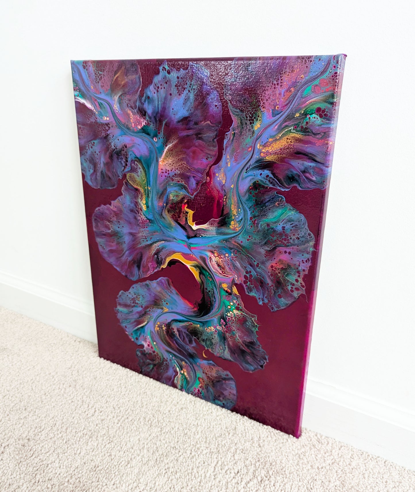 An expressive abstract fluid painting titled 'Ember Glow,' with a rich burgundy background illuminated by a vibrant blend of warm and cool tones. Fiery pinks and gold create a striking contrast, resembling glowing embers in motion