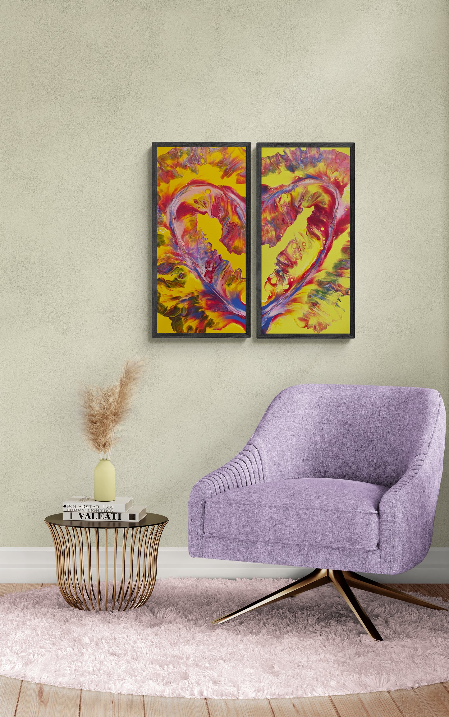 Framed two-canvas heart-shaped abstract painting with bright yellow, pink, red, and lavendar tones, hanging on a light beige wall above a round gold side table and lavender accent chair on a pink rug in a cozy, styled room.
