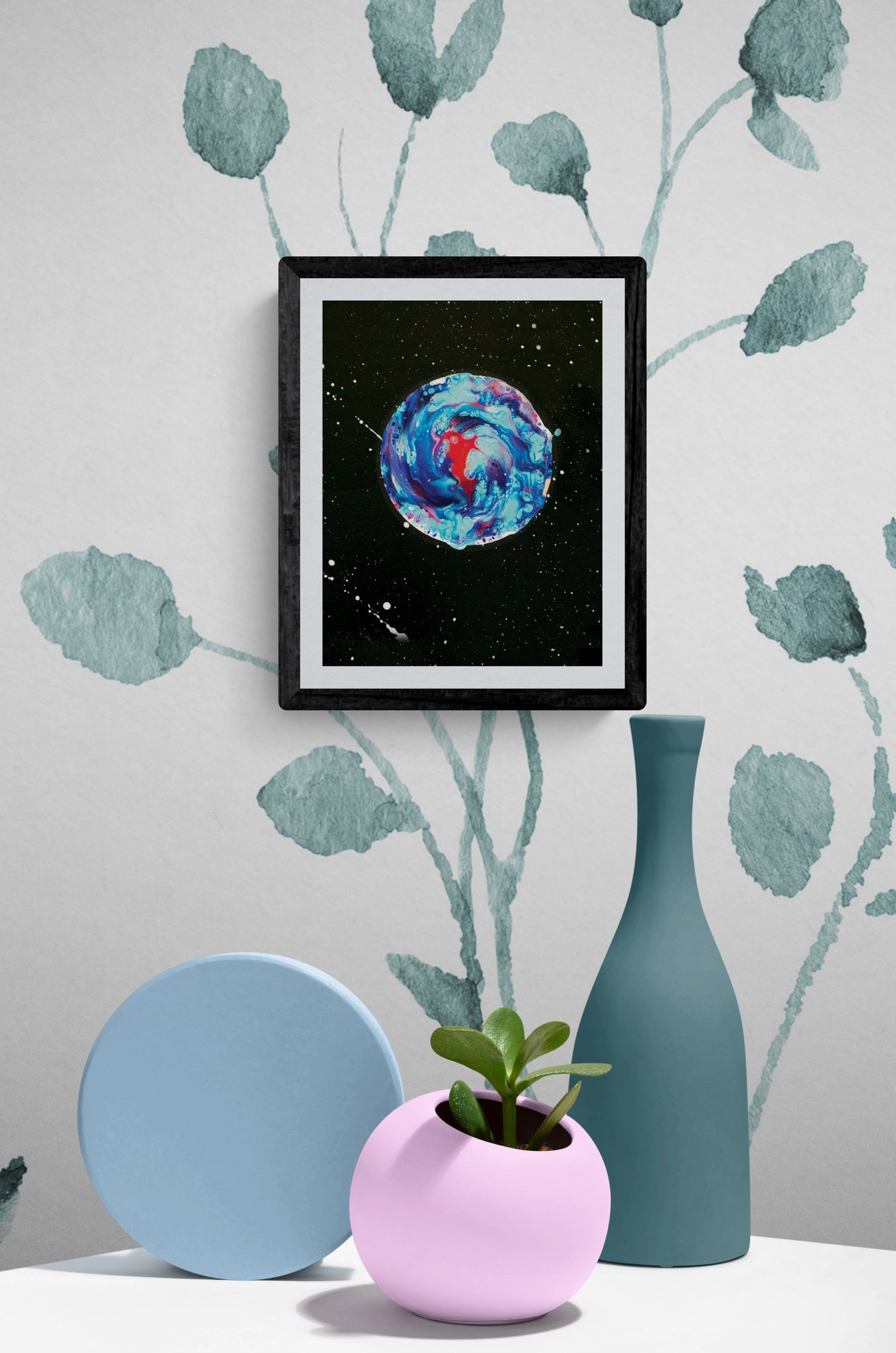 Her Majesty The Moon abstract art print in black frame, styled in a modern decor setting with pastel ceramics, green vase, and botanical wallpaper