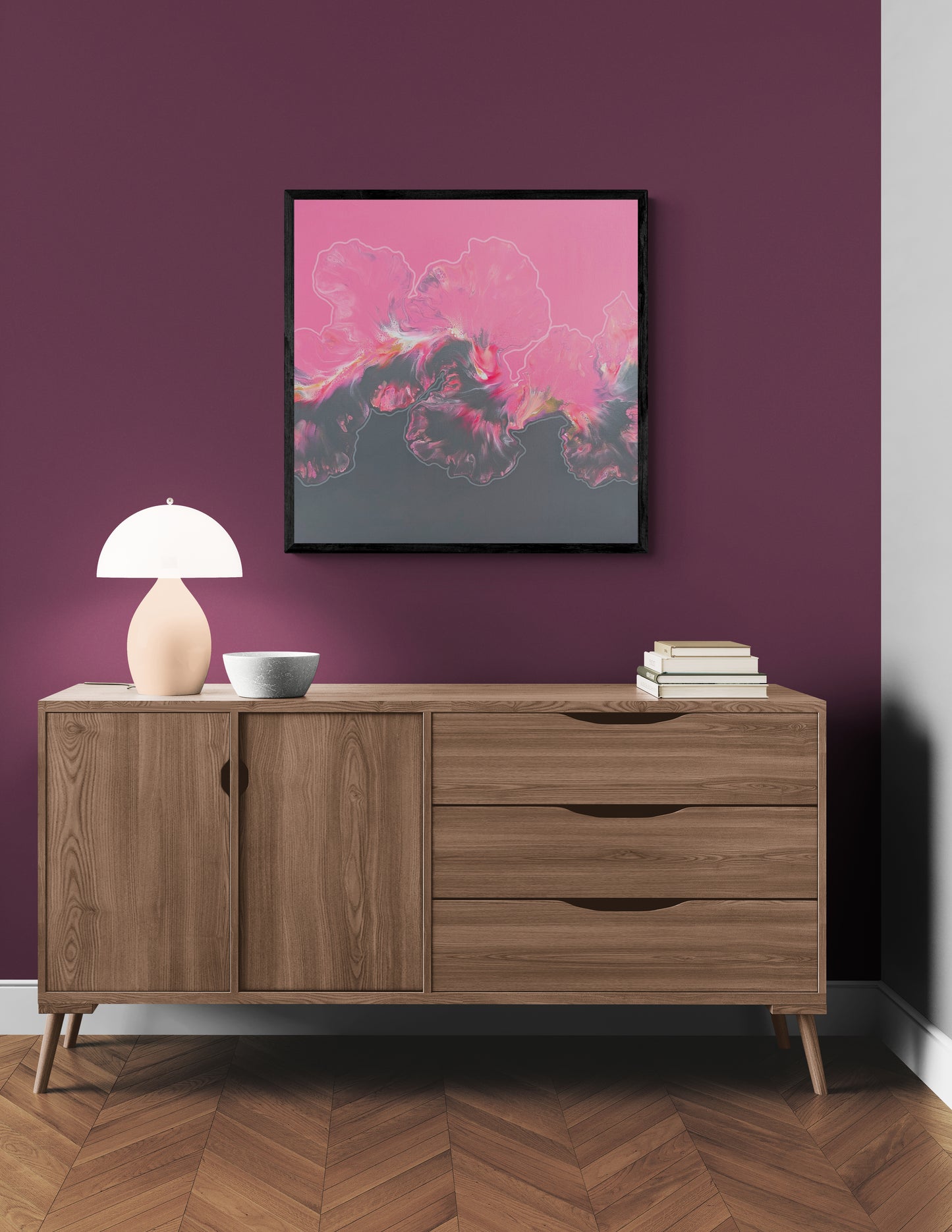 Abstract painting titled “In My Bliss” featuring vivid pinks and deep gray, displayed on a dark plum wall above a mid-century wood credenza with soft lighting.