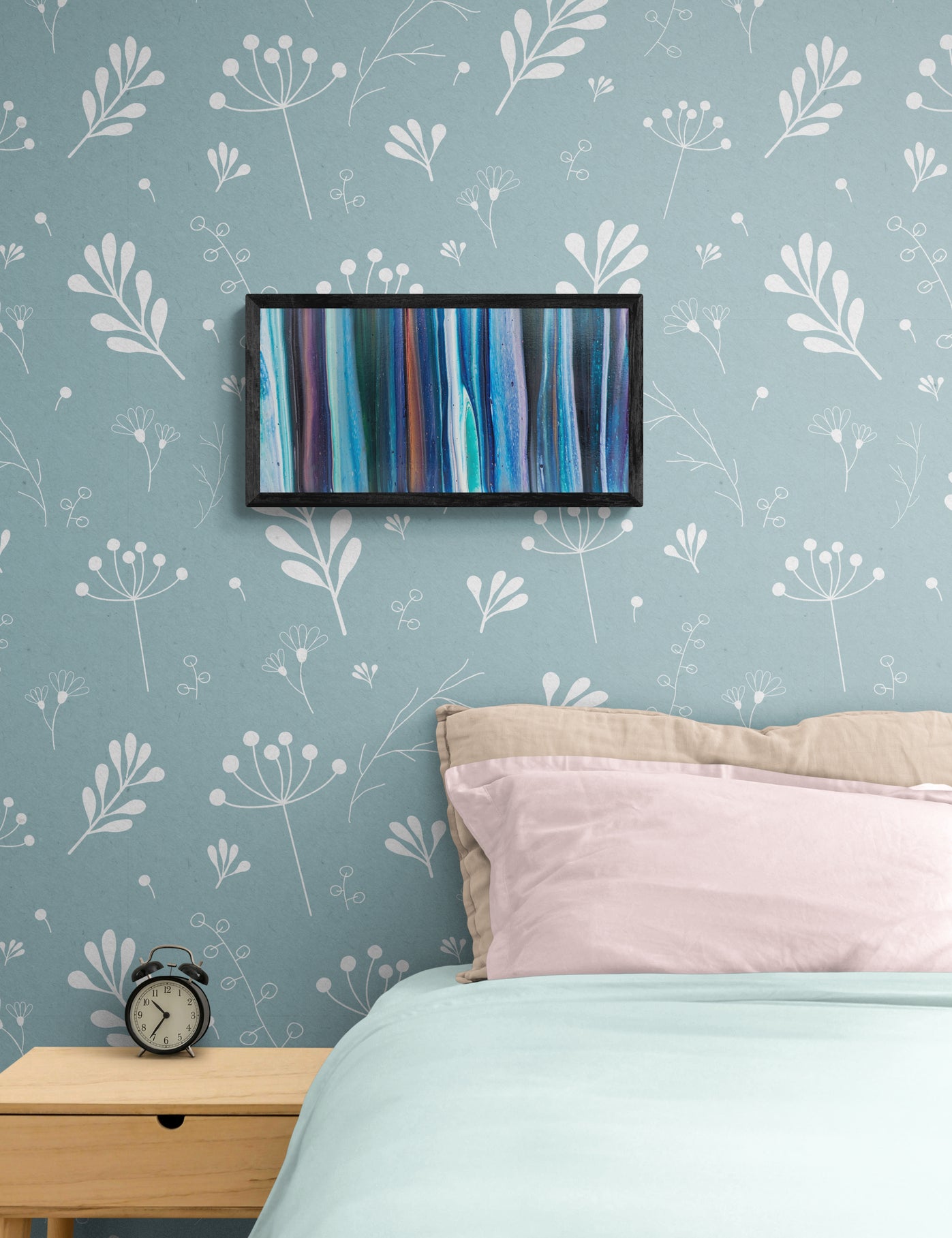 Framed fluid acrylic painting with vertical flows of deep blue, teal, and violet hanging on a soft blue floral wallpapered wall above a cozy bed with blush and aqua bedding and a light wood nightstand.