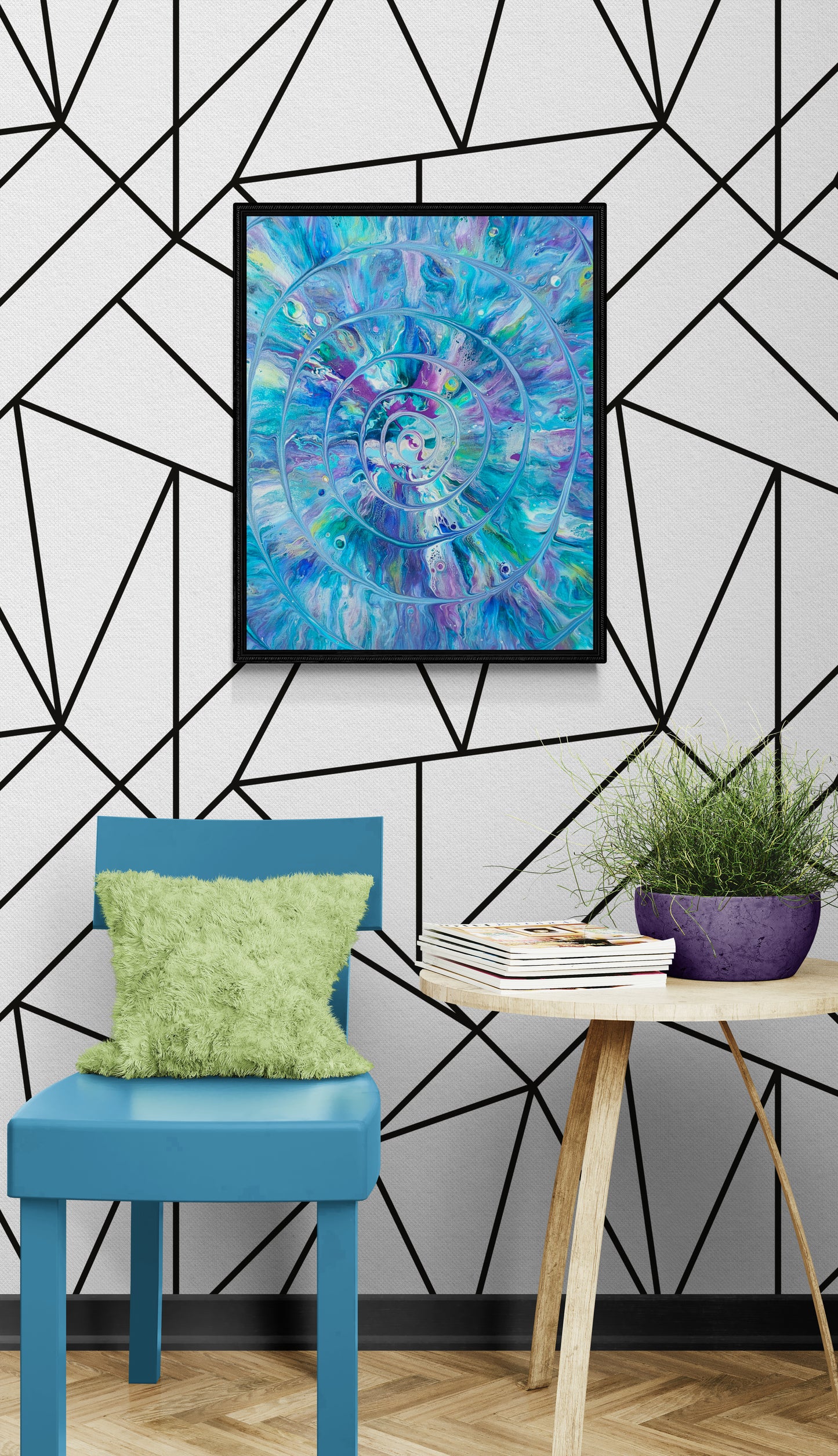 Peacock Swirl painting with vivid blues, purples, and teals displayed in a black frame against a white wall with a geometric black line pattern. The artwork features a spiral pattern radiating from the center. Styled in a modern space with a blue chair, green fuzzy pillow, small wooden table, books, and a purple planter with greenery.