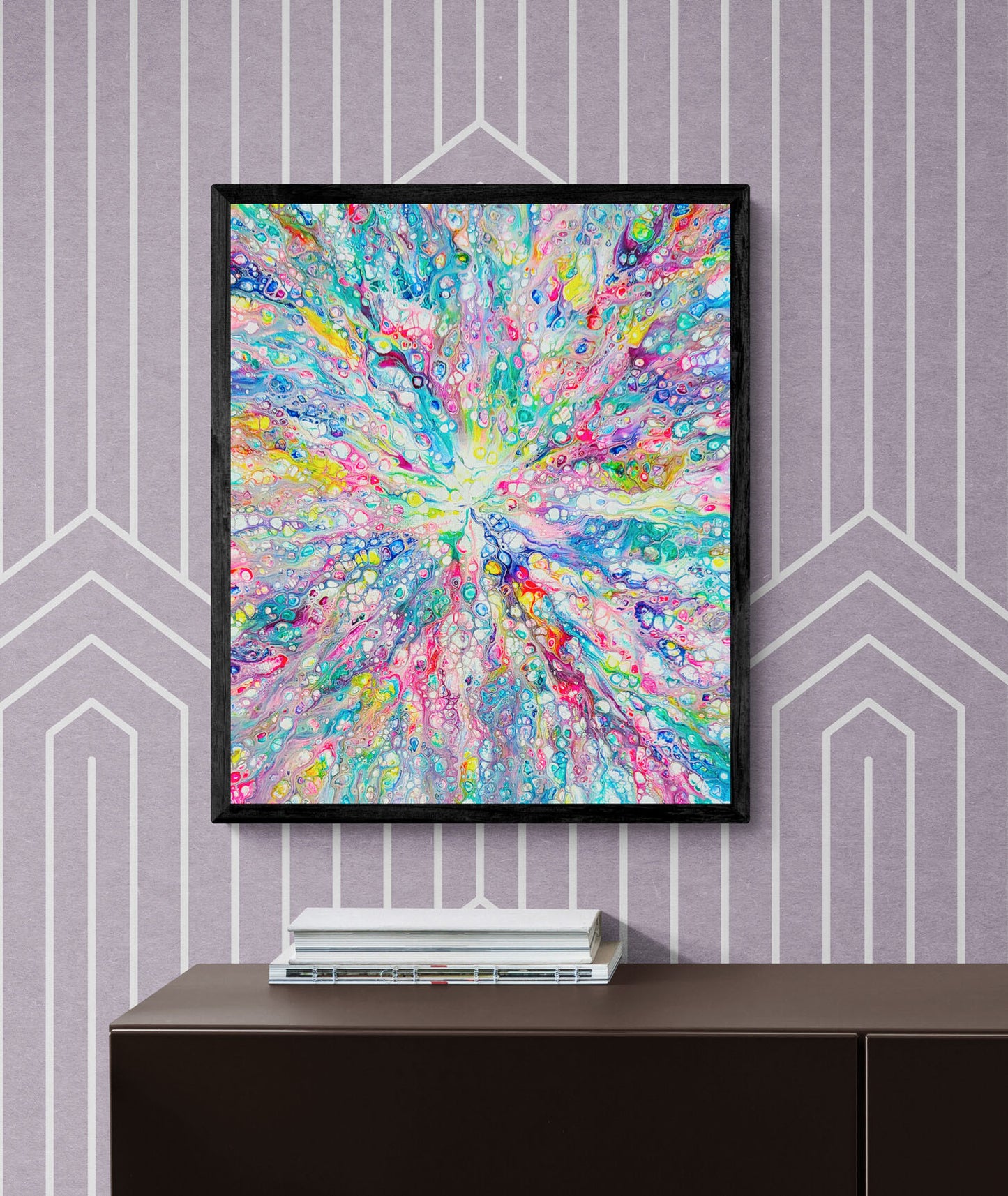 Rainbow Dragon fluid art wall print in vivid rainbow hues, framed in black and styled on a purple geometric patterned wall.