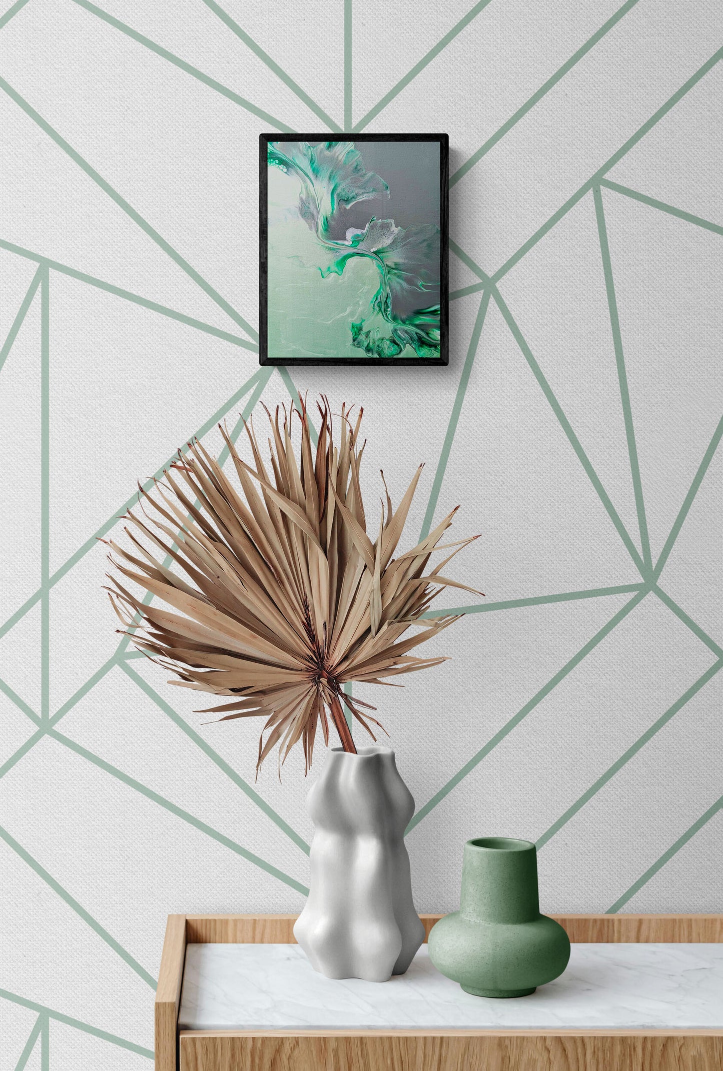 Sea Glass – abstract fluid art print in soft green, teal, and gray, framed wall decor above a modern console with vases and dried palm leaf.