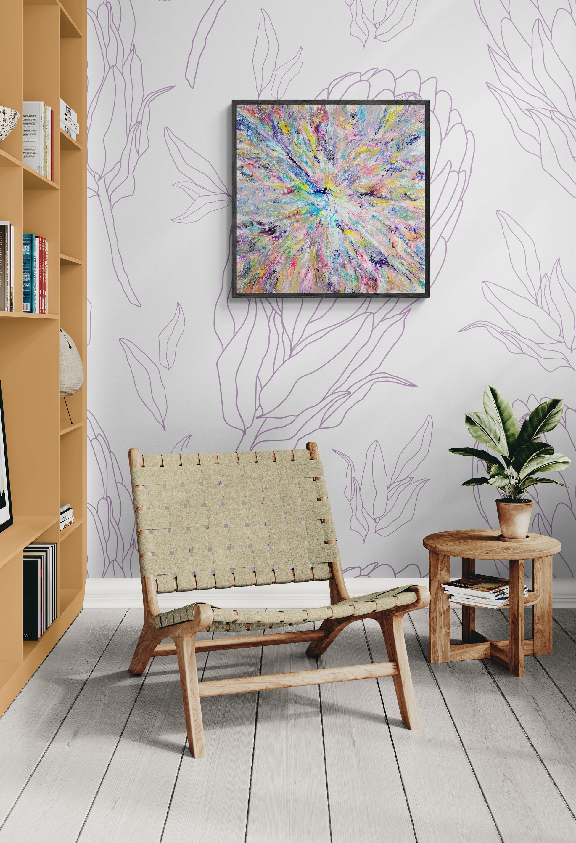A colorful abstract painting with a central rainbow burst and intricate cell textures hangs on a wall with soft purple floral linework. The room features a light wood woven lounge chair, a small round wood side table, and a leafy potted plant. A mustard-colored built-in shelf adds warmth and contrast, creating a cozy, modern, and whimsical space.