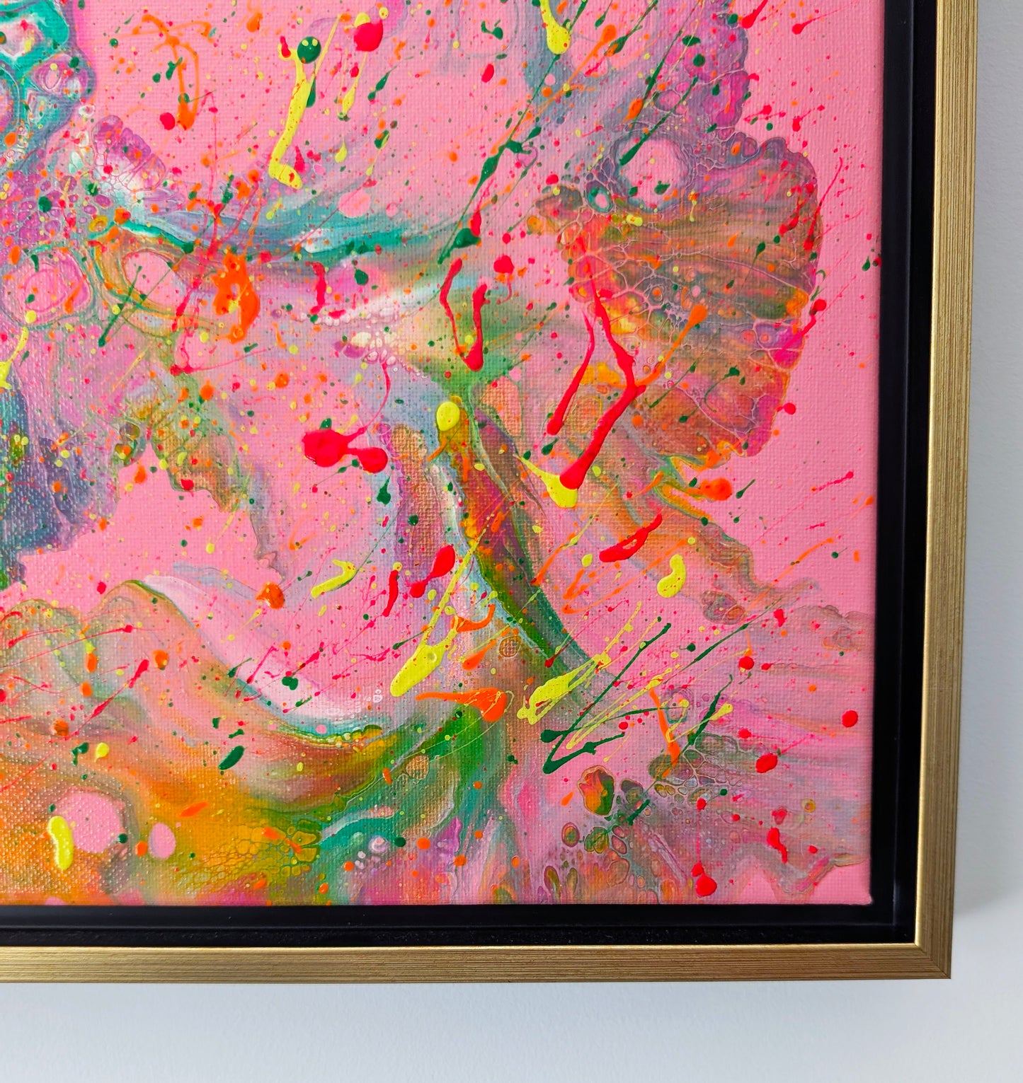 Close-up of the bottom right corner of the painting, highlighting swirling shapes in green, orange, and pink with vibrant paint splatters layered on top. Subtle lacing and cell textures create depth.