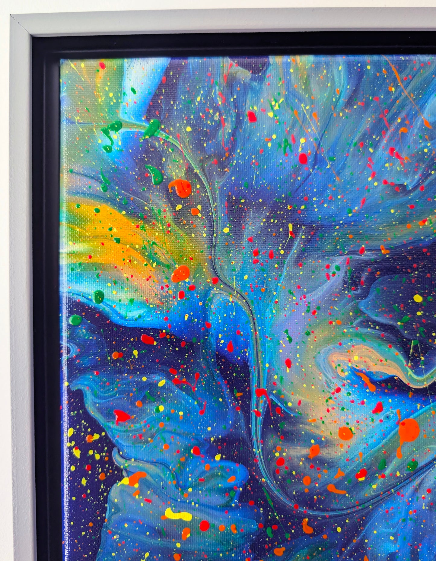 Zoomed-in section of the upper left, highlighting a mix of bold blue tones, soft gradients, and vivid paint splatter in red, yellow, and green.