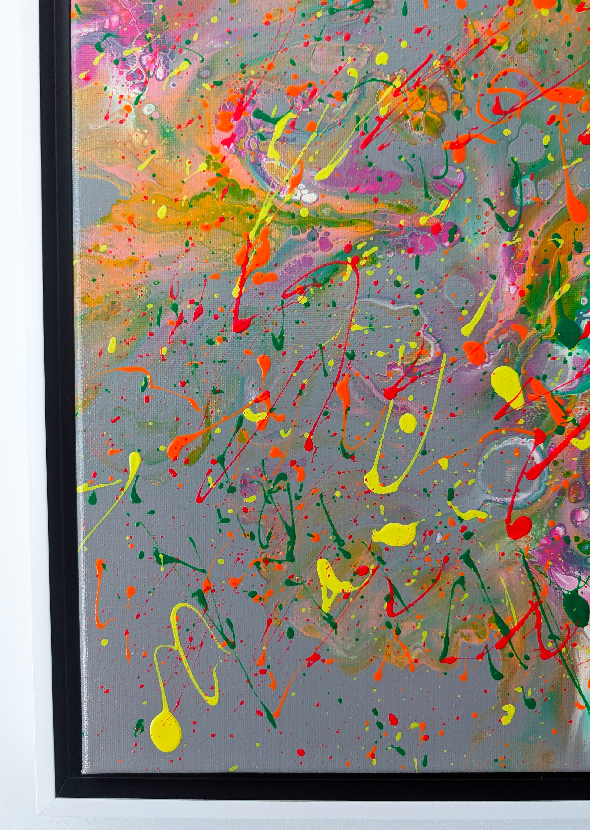 Close-up of the lower left corner of a fluid acrylic painting, focusing on intricate cell-like textures, layered paint swirls, and vivid drips in green, pink, and yellow.