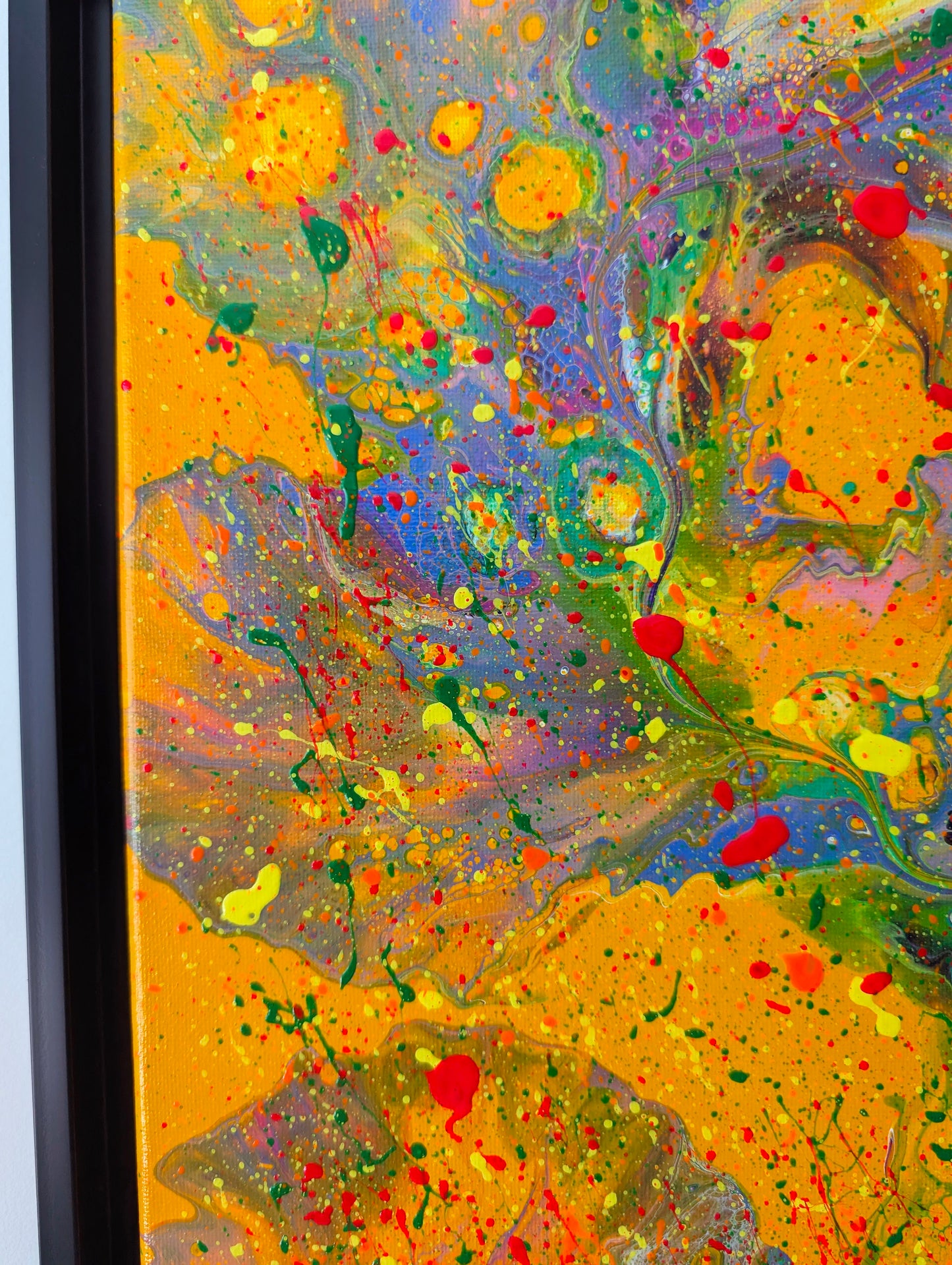 Close-up of the left side of the painting, emphasizing detailed green, pink, and purple swirls blending into the yellow background. Paint splatters in red and green add dynamic contrast.