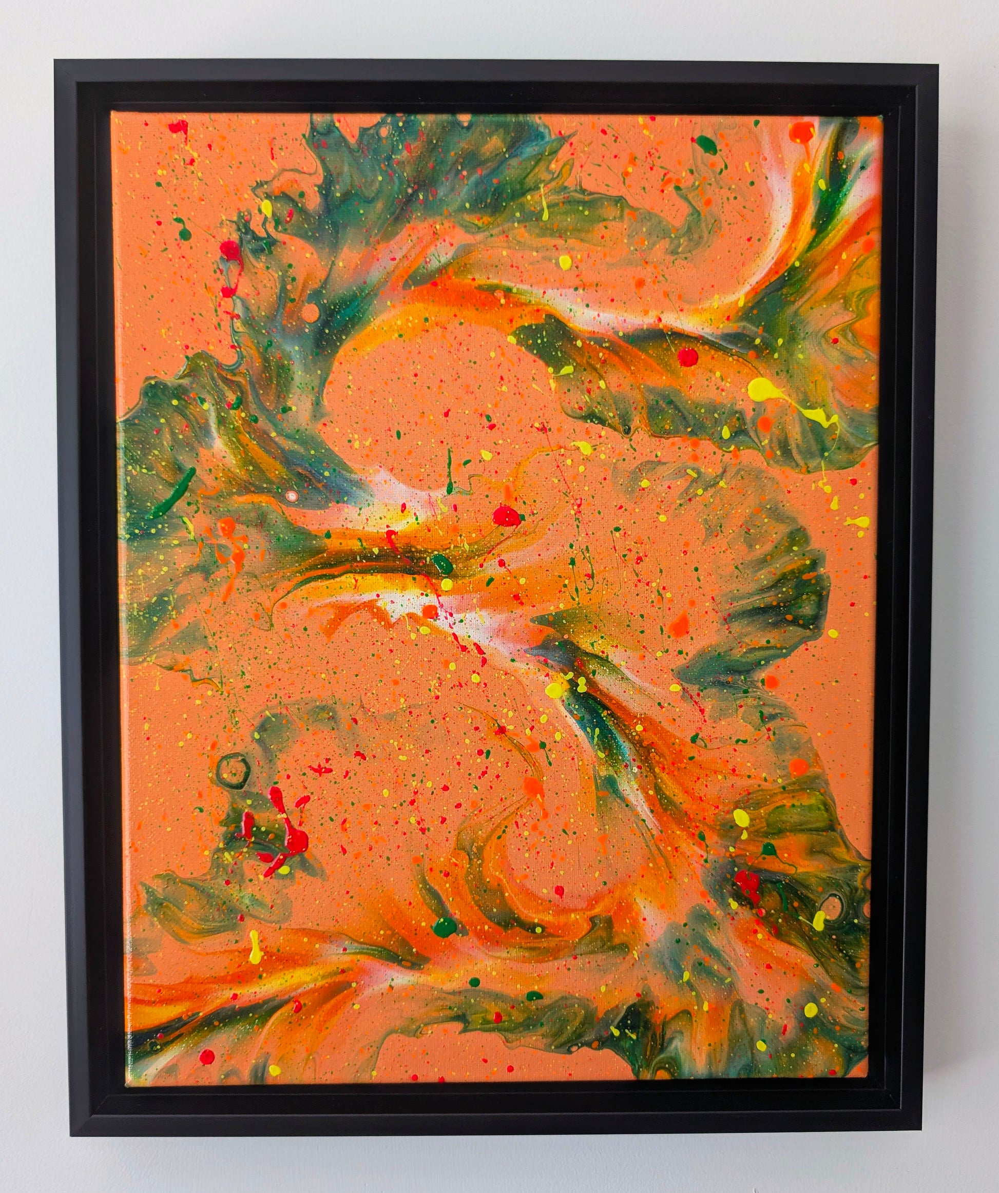 Original abstract fluid art painting titled 'Are You Really Going Out in That?' featuring bold green and dark marbled swirls over a fiery orange background, layered with vibrant splatters of yellow, red, and neon orange. Displayed in a black floating frame against a white wall.