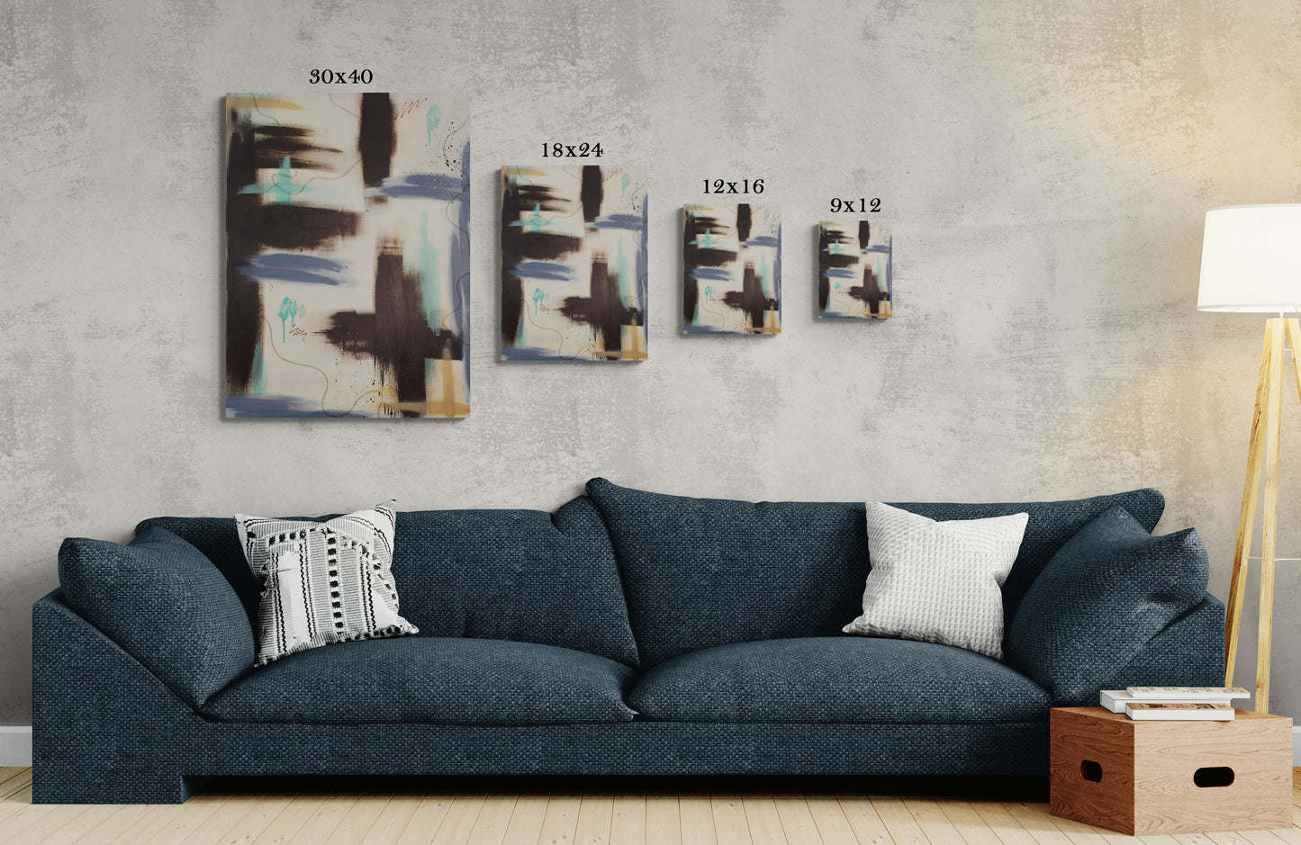 A size comparison guide for the "Between the Layers" canvas print, showing 30x40, 18x24, 12x16, and 9x12 sizes hanging on a concrete-textured wall. The art features raw umber and teal abstract shapes, positioned above a deep navy blue contemporary sofa.