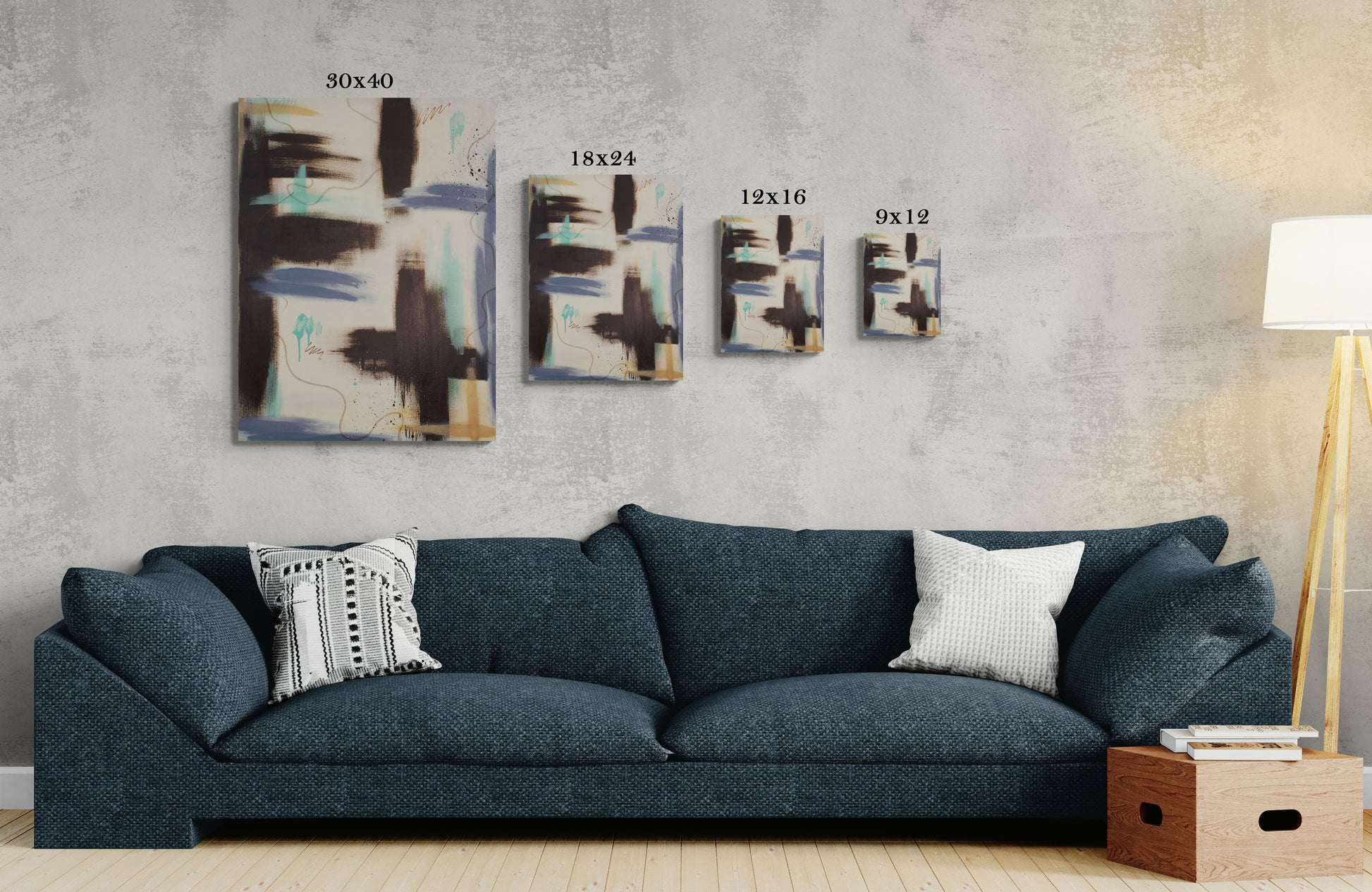 A size comparison guide for the "Between the Layers" canvas print, showing 30x40, 18x24, 12x16, and 9x12 sizes hanging on a concrete-textured wall. The art features raw umber and teal abstract shapes, positioned above a deep navy blue contemporary sofa.