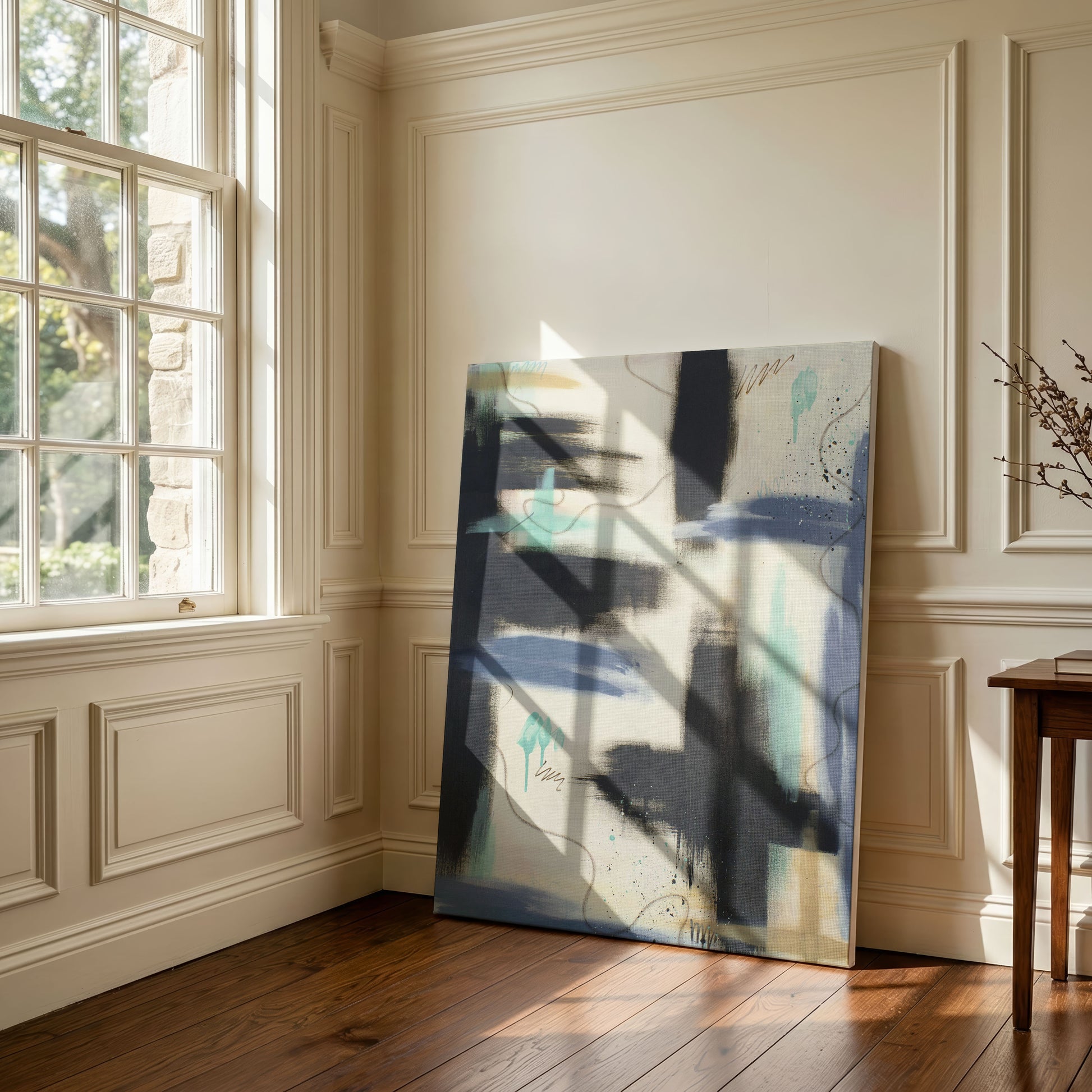 A large canvas print of the painting sitting against a wooden floor, leaning against a cream colored wall. It sits next to a large, paned window with sunlight streaming through.