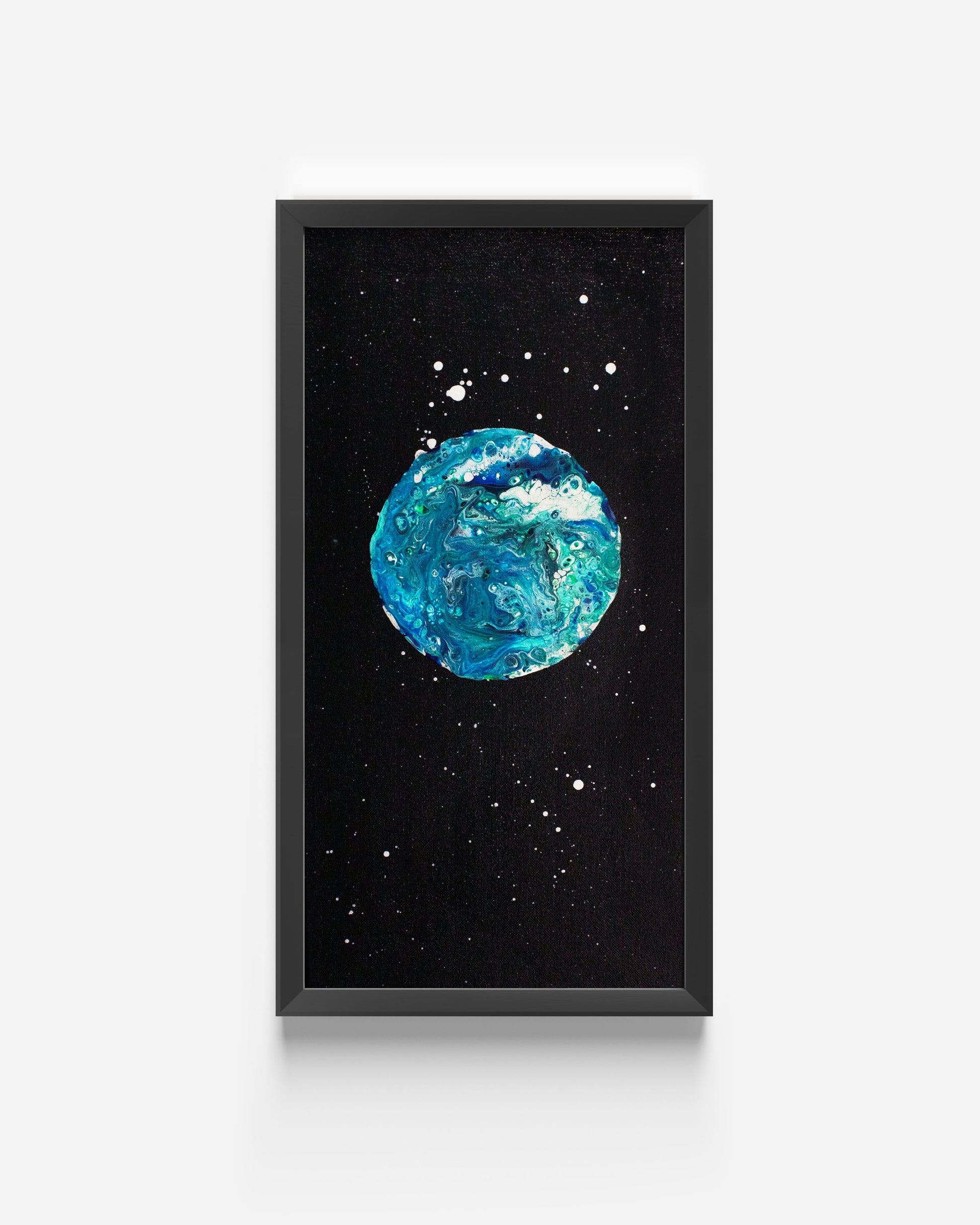 Close-up of the framed Blue Moon fluid acrylic painting with a black background and swirling turquoise textures, shown on a plain white wall.