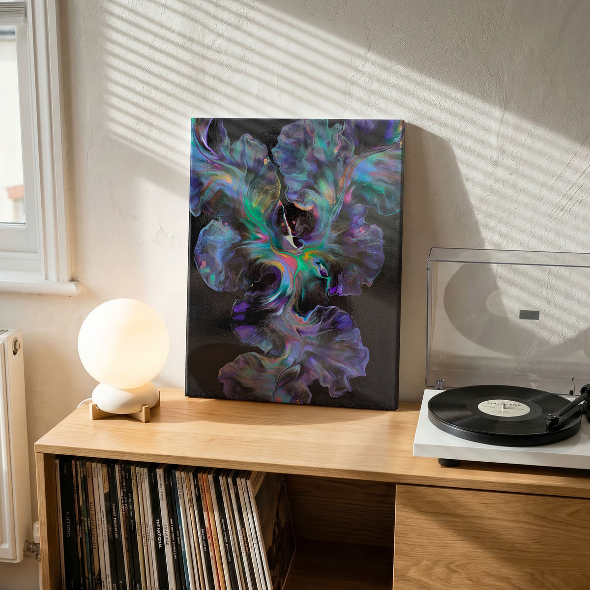 Celestial Dance, an original fluid painting by Abby May, shown in a room on a shelf beside a record player.