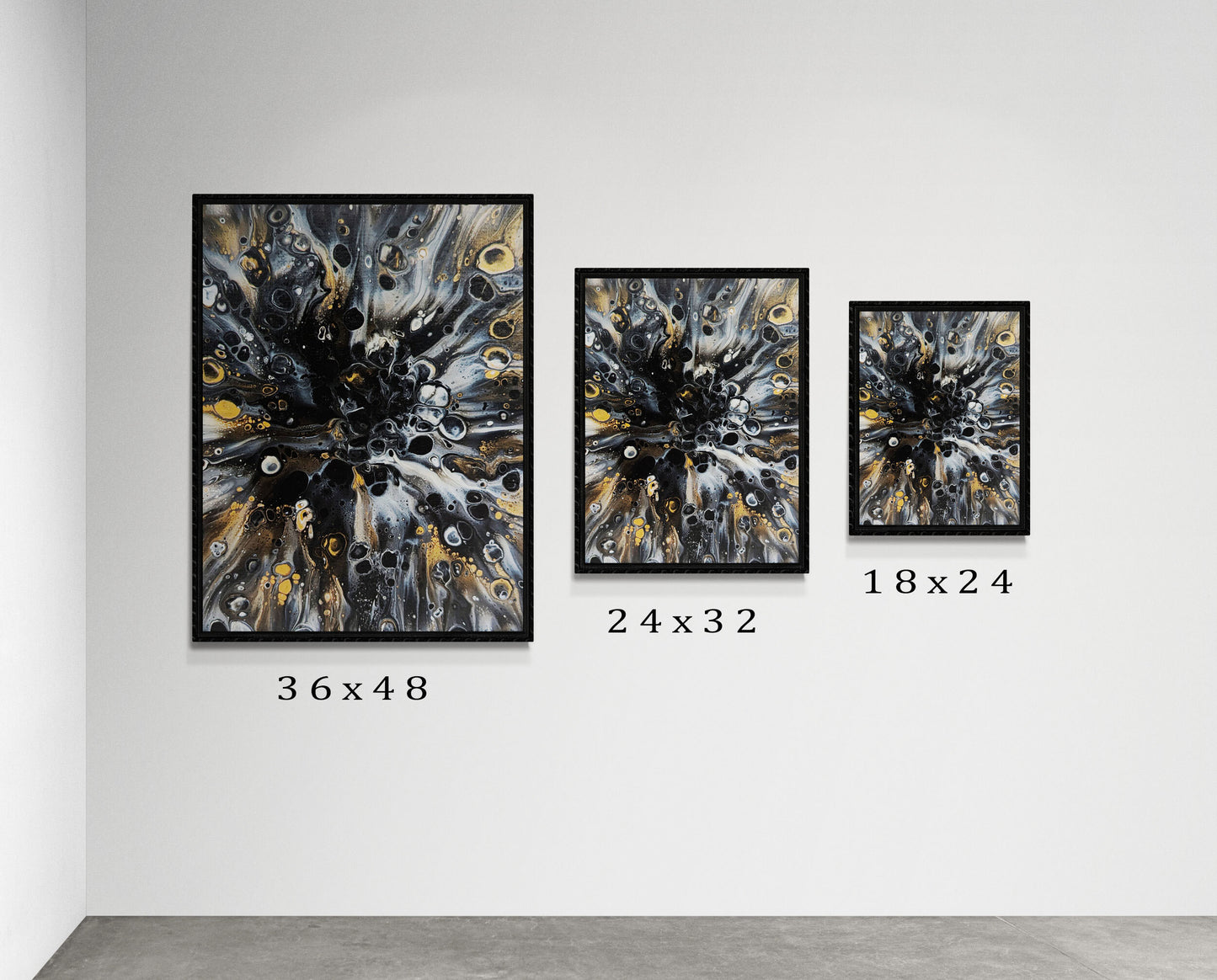 Three framed prints of Abby May’s Charm displayed on a neutral gallery wall in 36x48, 24x32, and 18x24 sizes. The artwork’s gold, black, and gray tones radiate in fluid, circular motion