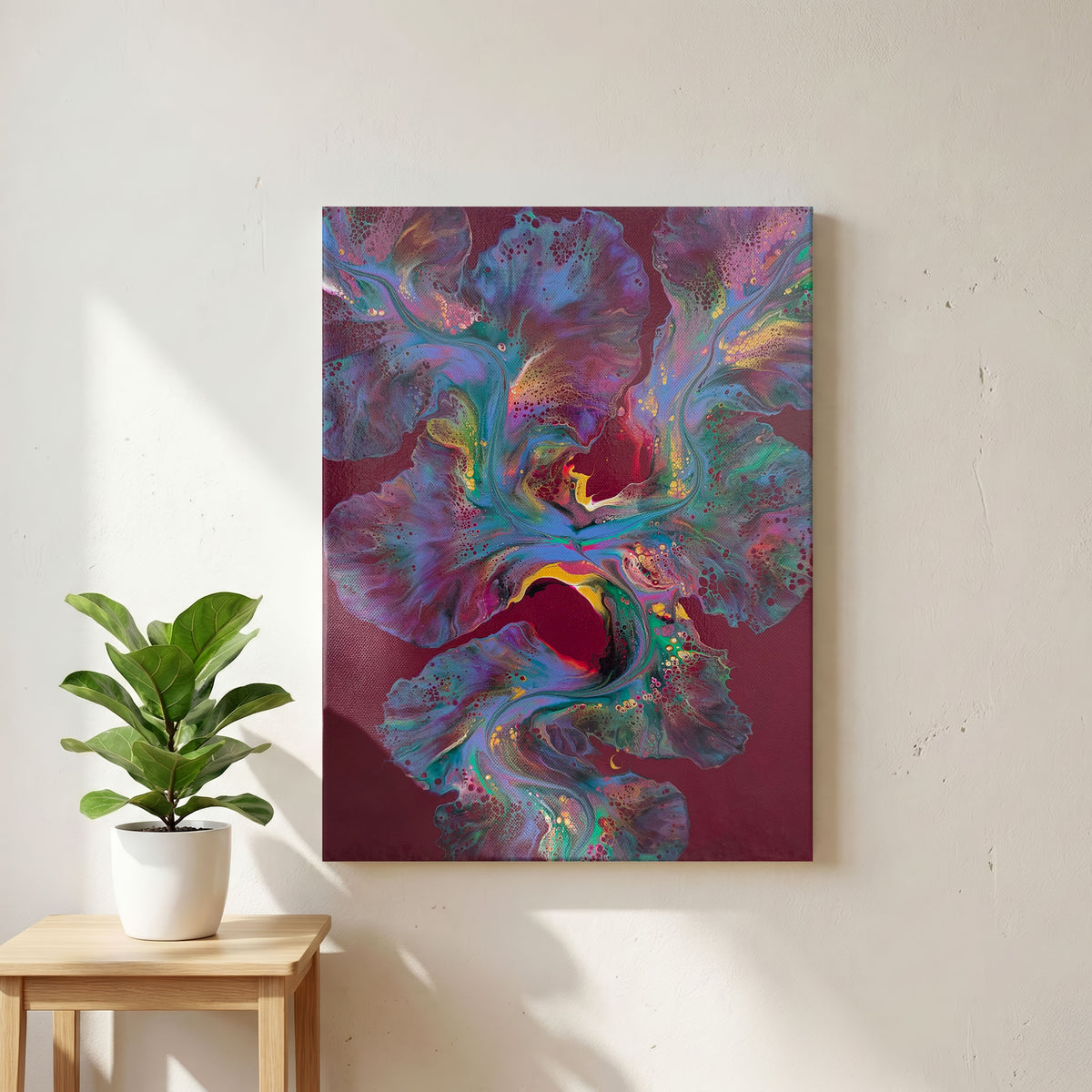 Ember Glow, an original fluid painting by Abby May, maroon with turquoise, lavender, and gold, shown straight on in a room beside a plant.