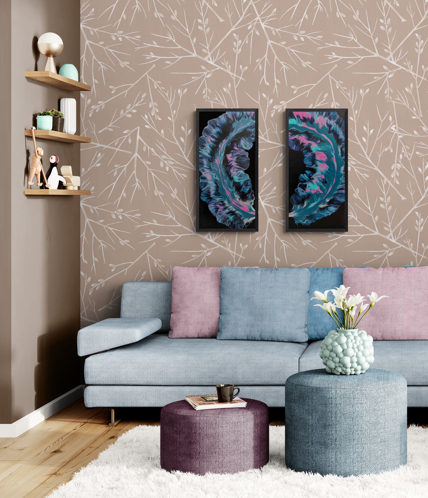Two framed abstract paintings featuring swirling turquoise, pink, and indigo tones displayed above a pale blue sectional in a cozy, modern living room with soft pastel pillows and floral decor.