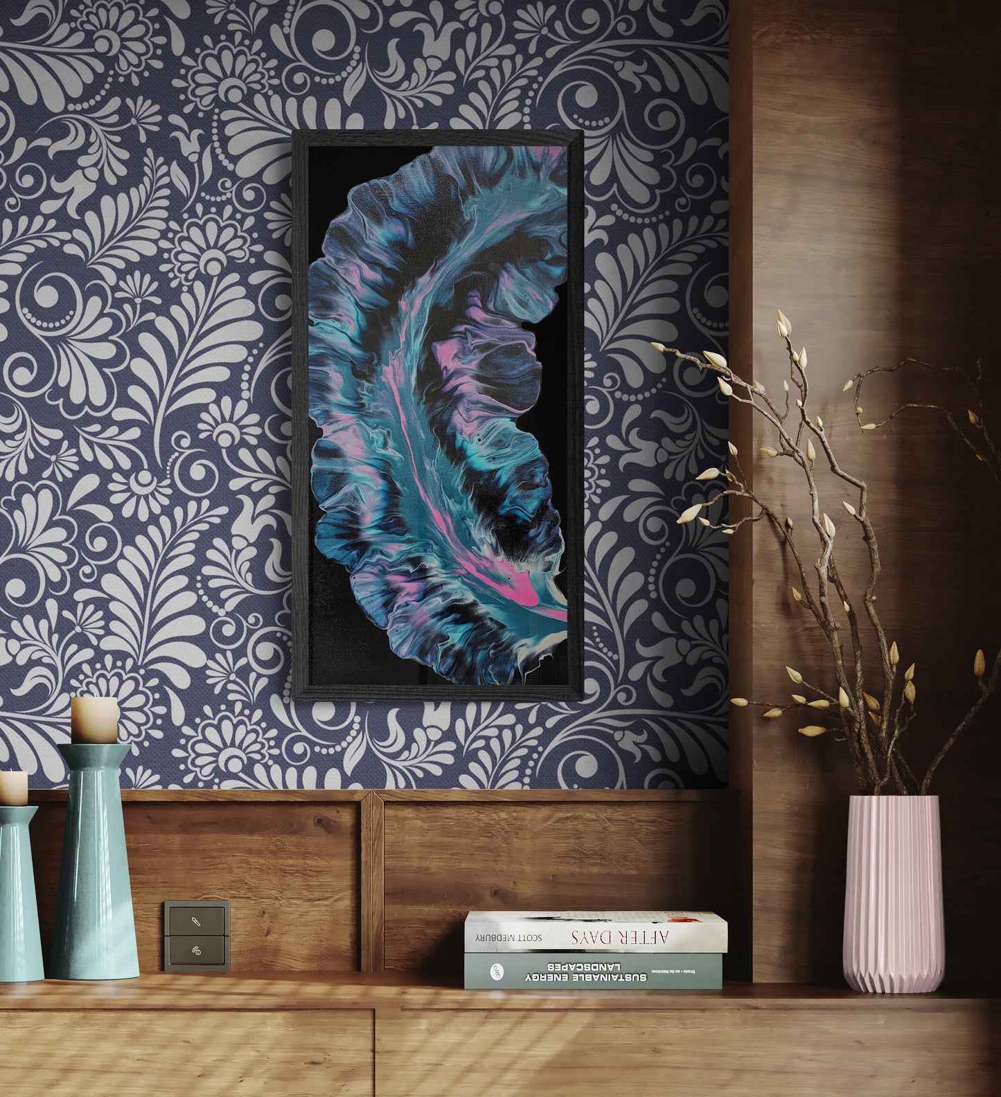 Framed abstract painting with glowing aqua, pink, and deep purple tones displayed on a navy floral wallpapered wall above a wood console with pastel vases, candles, and books.