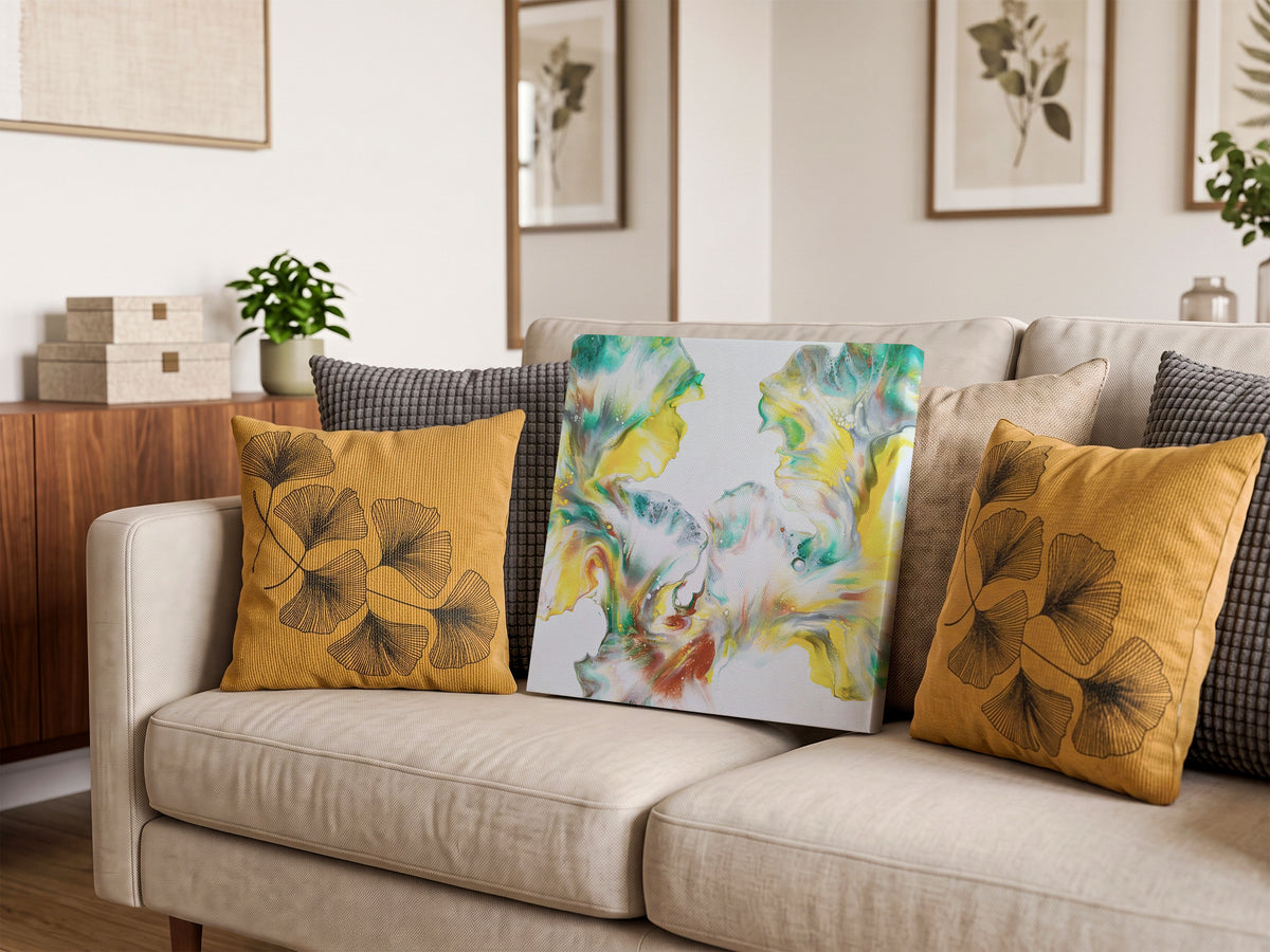 Daffodils of Spring, an original fluid painting by Abby May, yellow, teal, and green on white, shown straight on in a room on a couch.