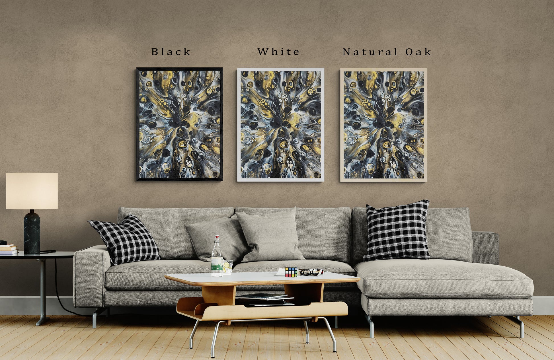 Abstract fluid art print in three frame options—black, white, and natural oak—mounted above a modern gray sofa with plaid pillows in a contemporary living room