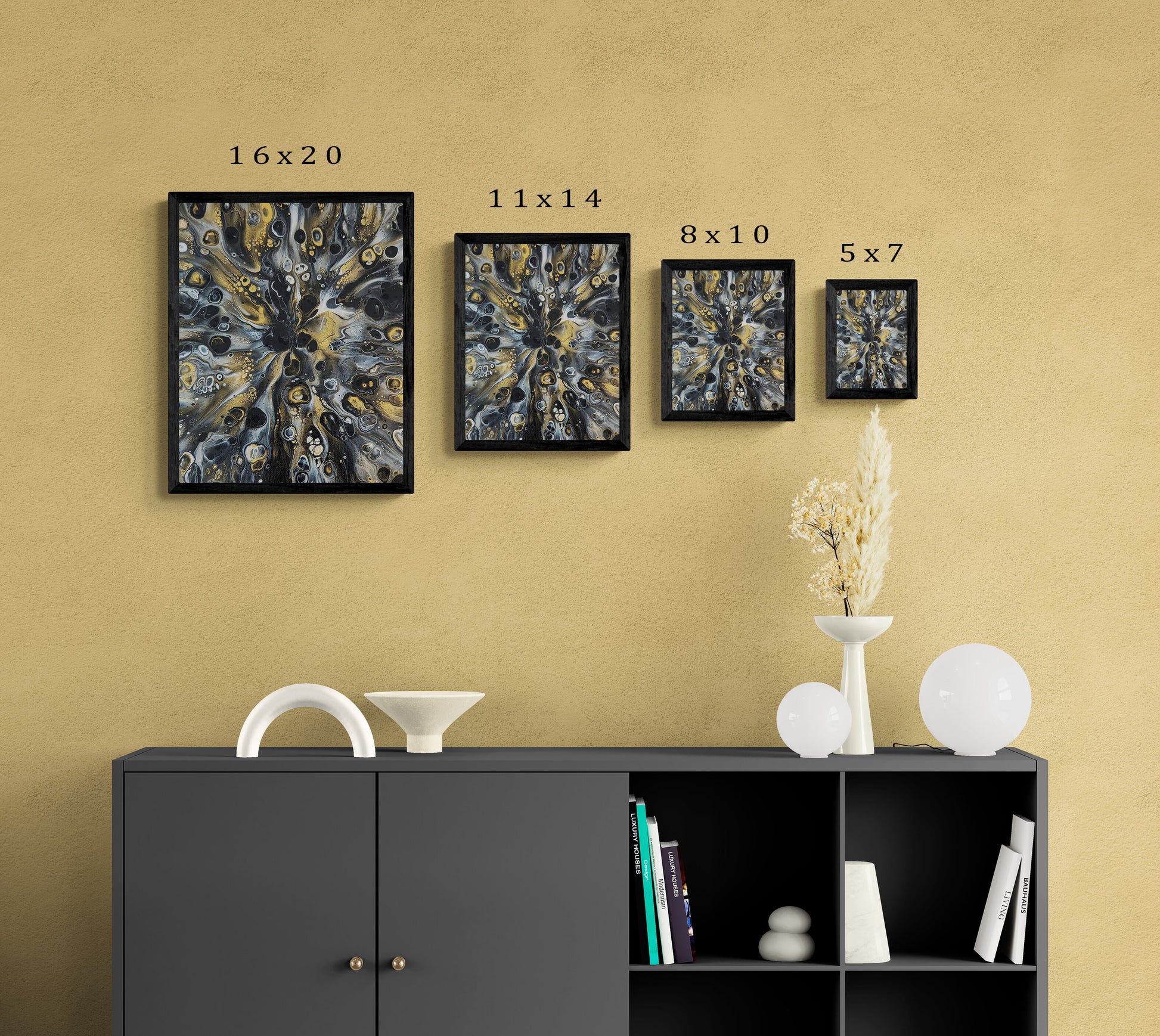 Abstract fluid art prints in black frames displayed in four sizes—16x20, 11x14, 8x10, and 5x7—on a mustard wall above a modern black console with decor and books