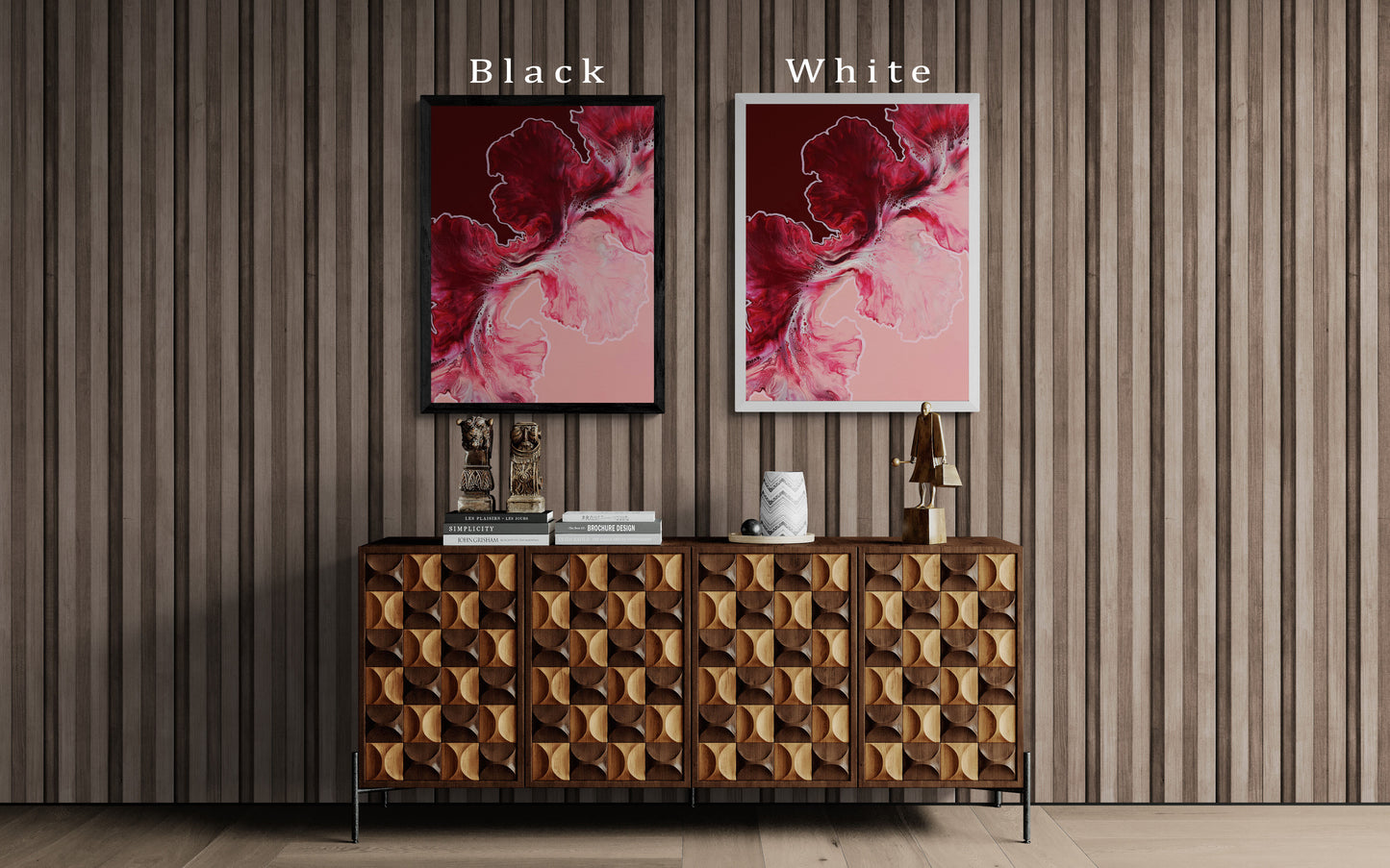 Abstract red and pink fluid art prints shown in two frame colors—black and white—displayed above a textured wood cabinet with sculptural decor.