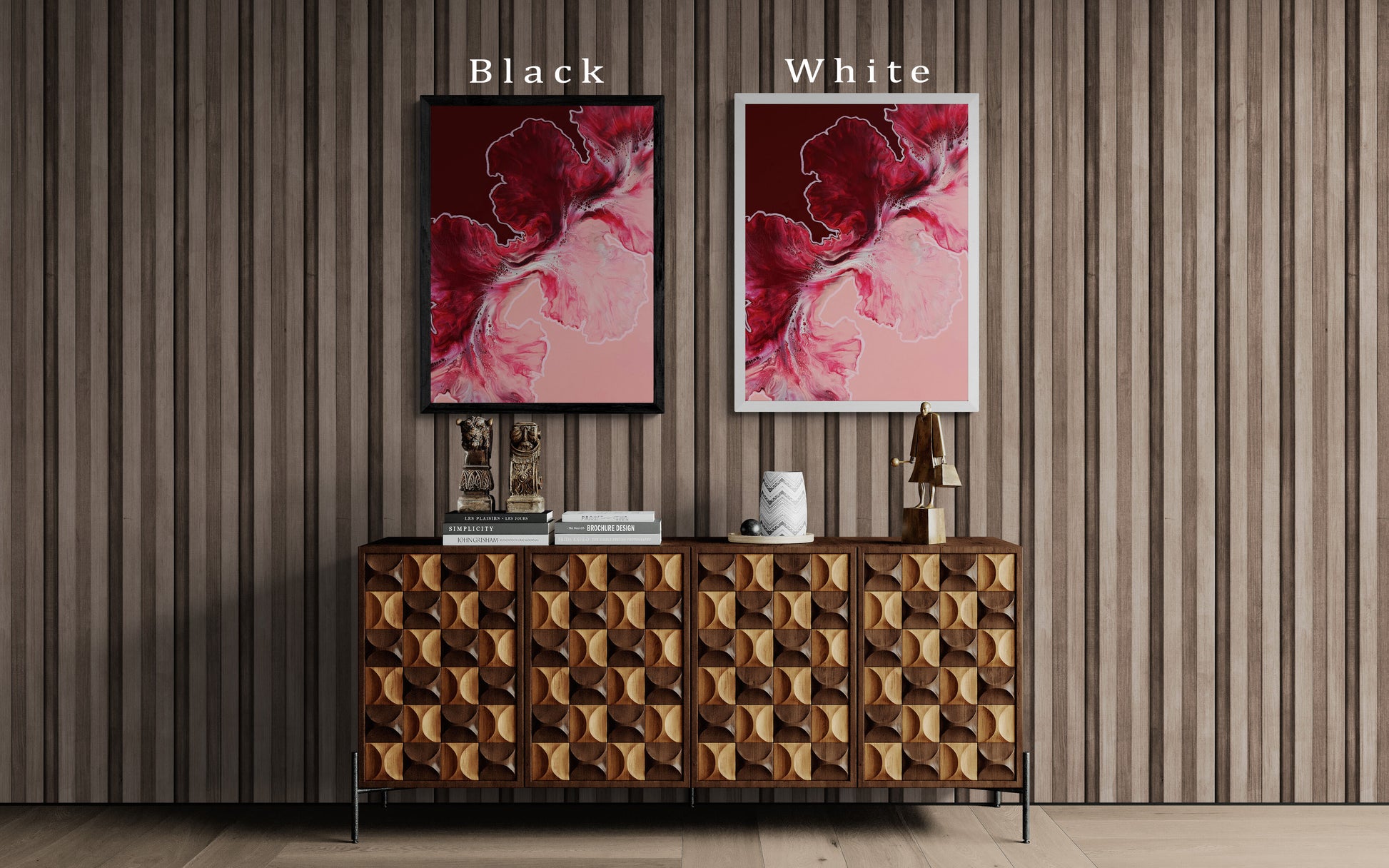 Abstract red and pink fluid art prints shown in two frame colors—black and white—displayed above a textured wood cabinet with sculptural decor.