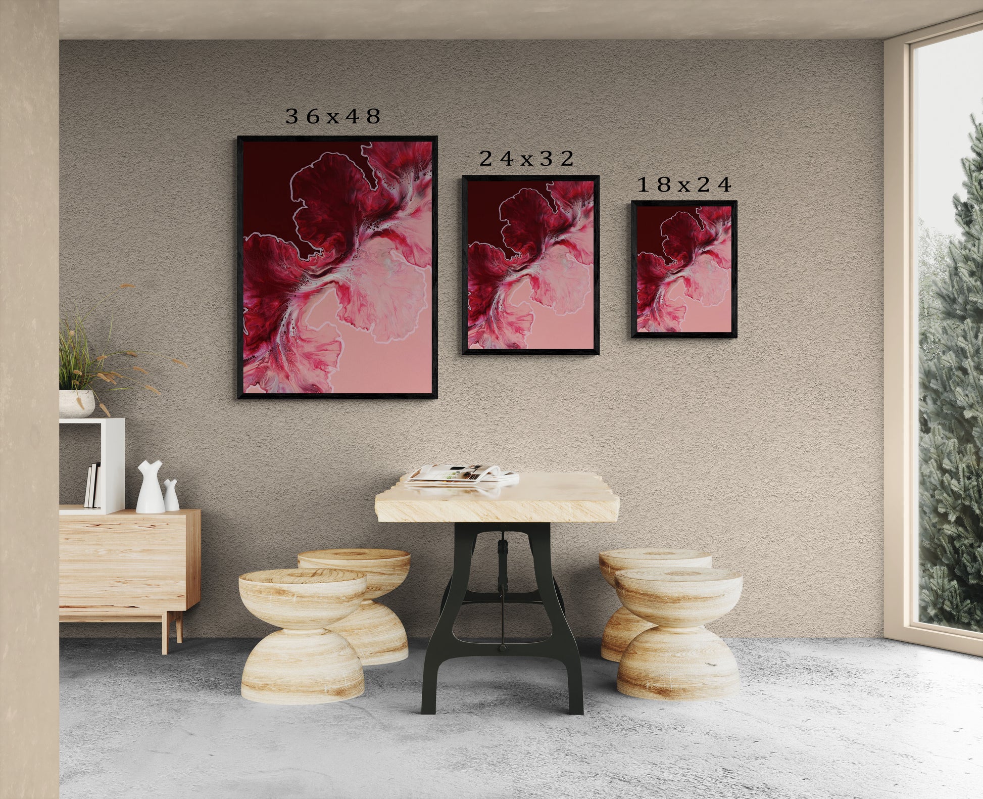 Abstract red and pink fluid art prints in black frames displayed in three sizes—36x48, 24x32, and 18x24—above a modern wood table with light wood stools.