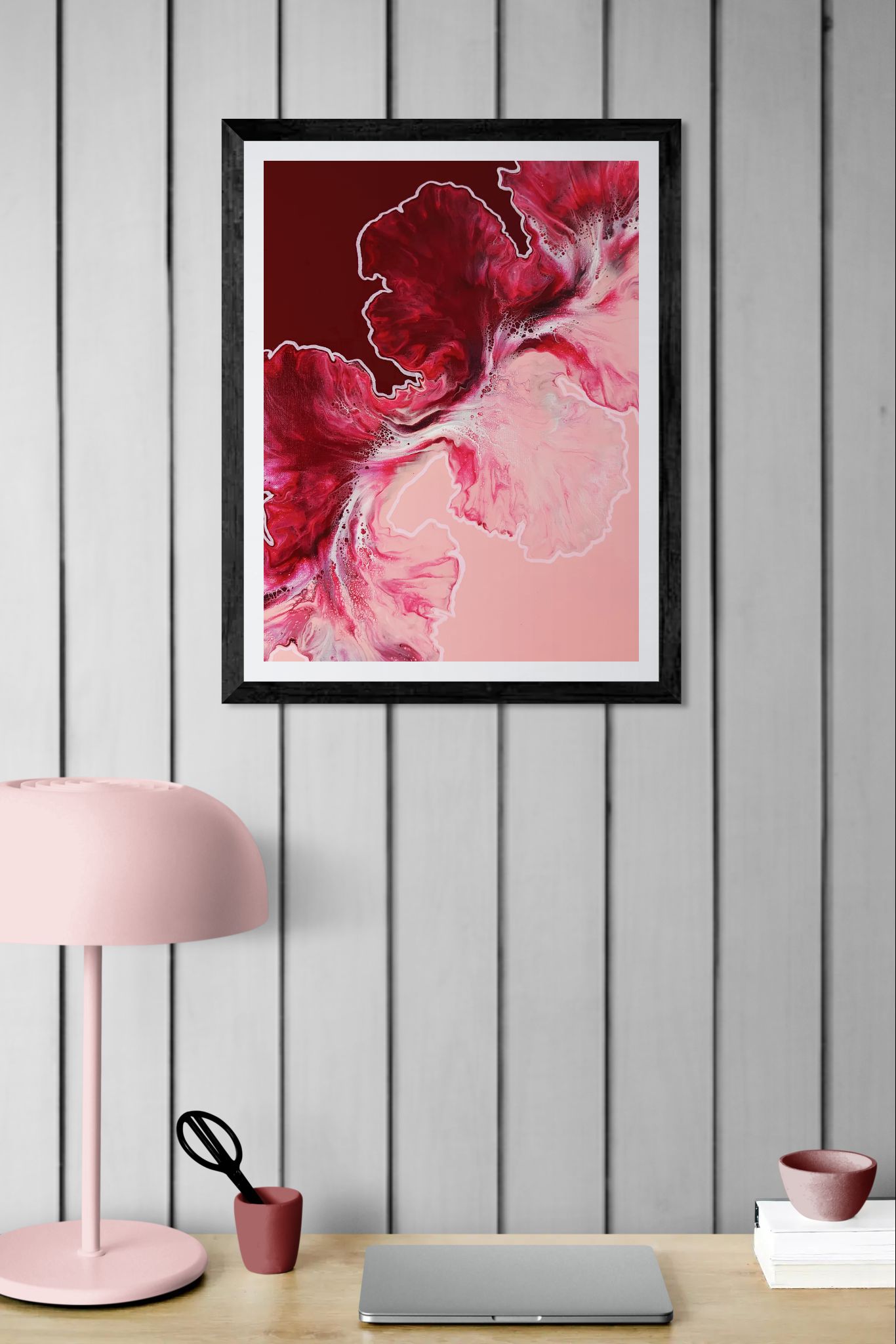 Hold the Line fluid art print in deep red and light pink, framed on vertical wood panel wall above modern desk setup.