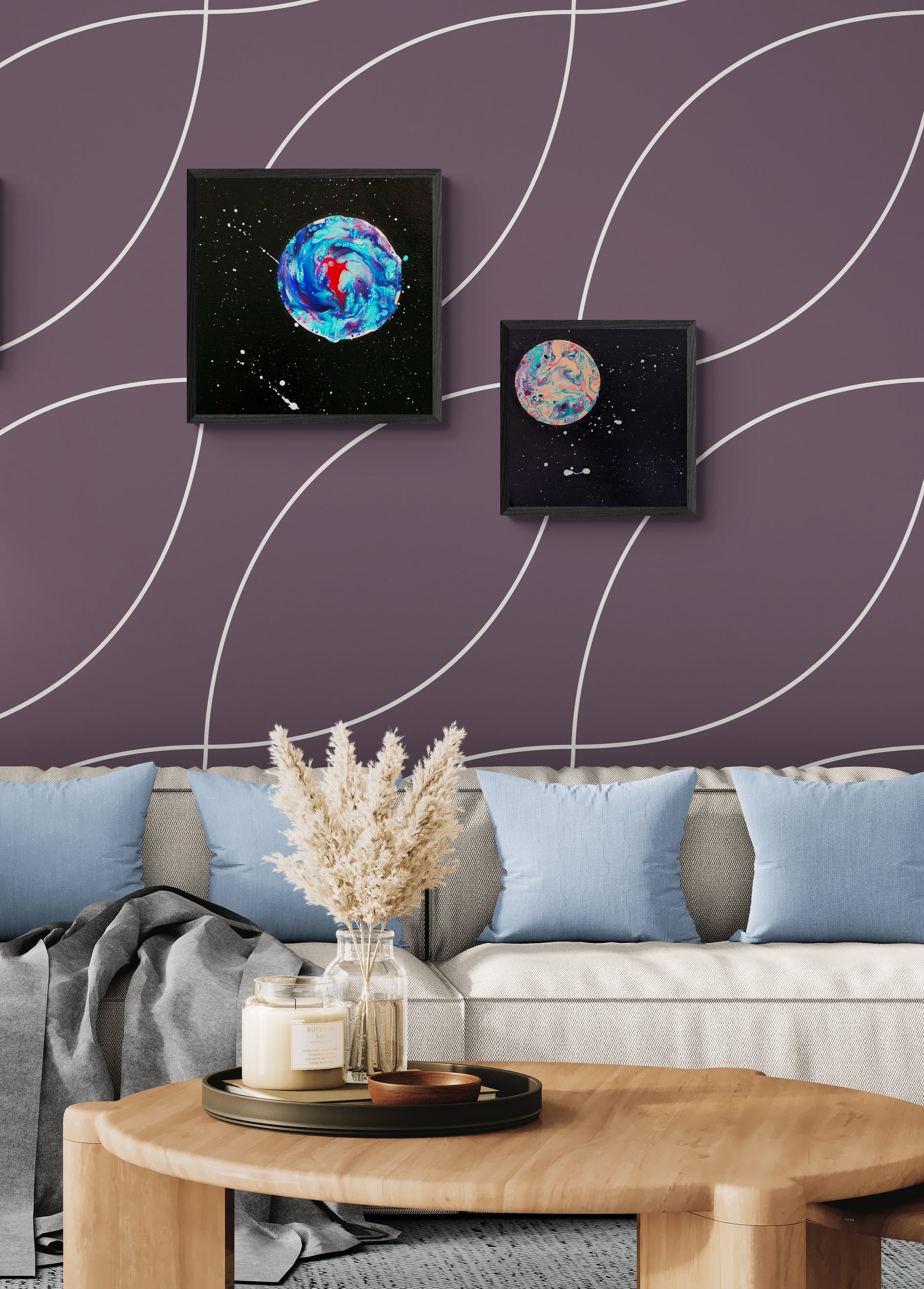 Her Majesty the Moon and Strawberry Moon displayed on plum-colored wallpaper above a modern neutral couch with blue pillows.