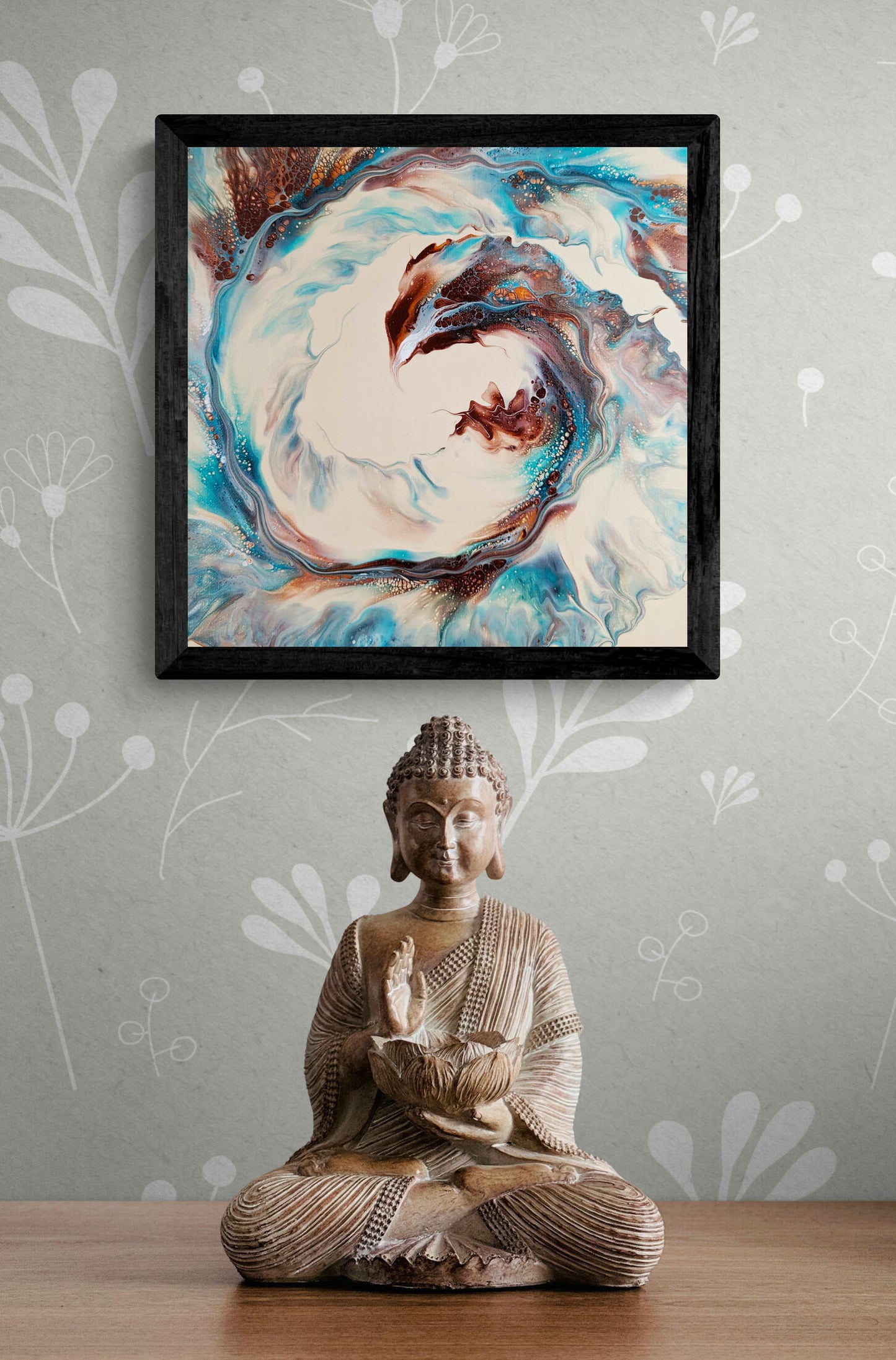 Framed Phoenix fluid art print with blue and copper tones, styled above a Buddha statue in a serene setting.