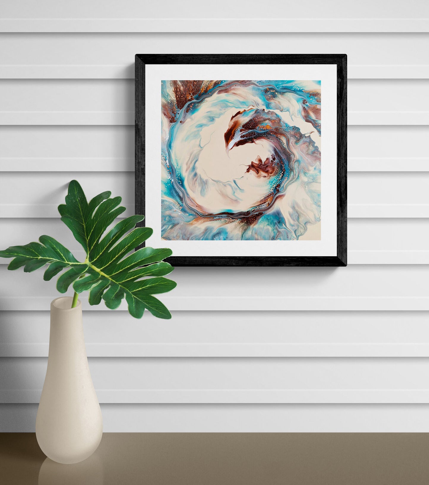 Phoenix abstract fluid art wall print in black frame, styled above a modern side table with tan vase.