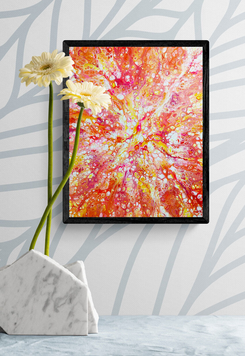 Framed “Phoenix Aflame” acrylic fluid art print with fiery red, orange, and yellow tones displayed on a patterned wall beside white flowers in a marble vase.