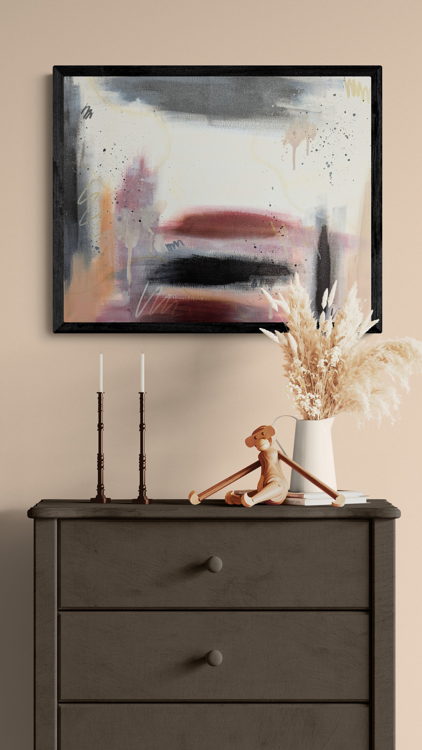 Framed abstract painting “Rooted” by Abby May displayed above a dark wood dresser with neutral decor, creating a calm and grounded interior scene.