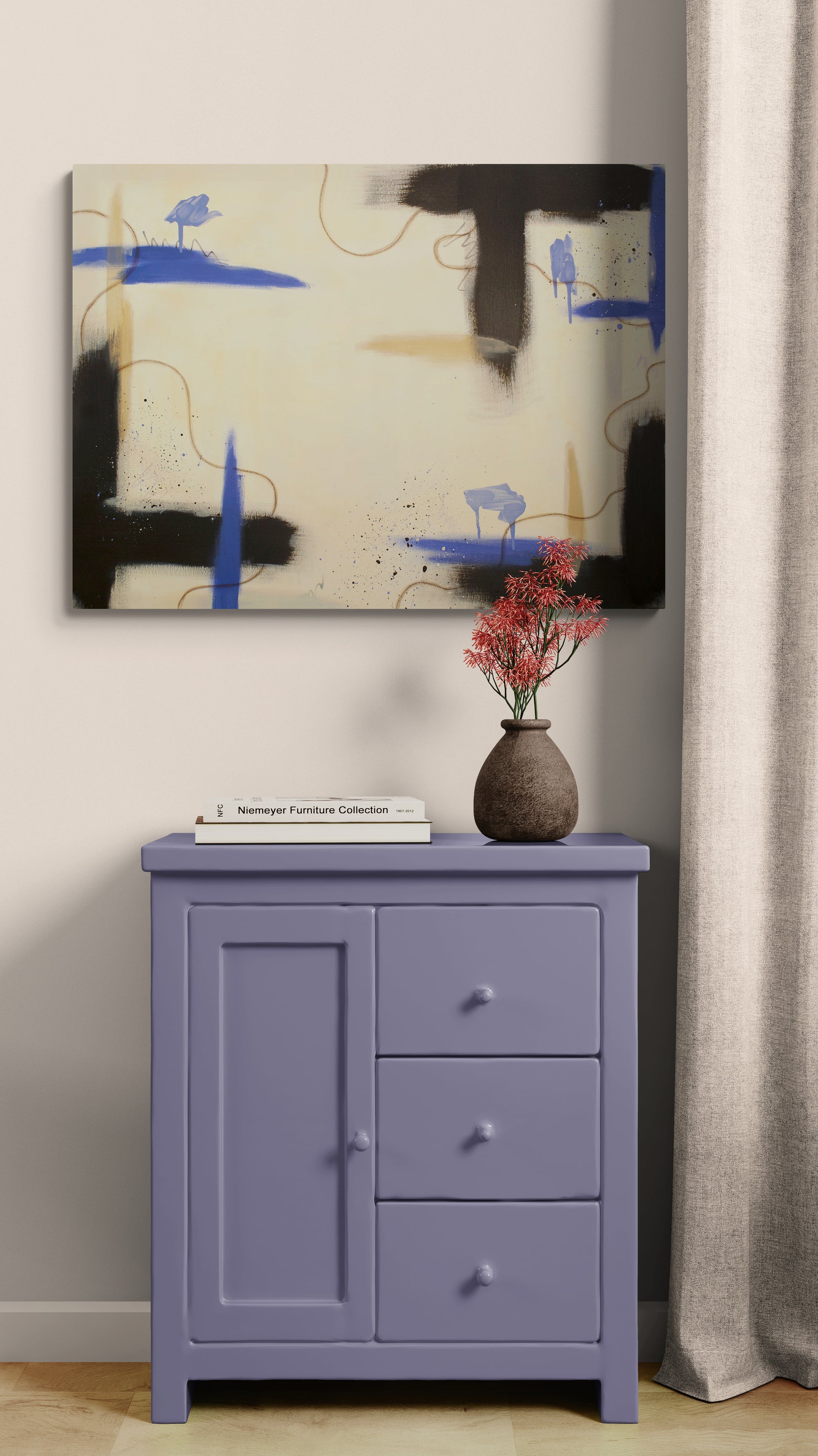 A contemporary abstract canvas print with raw umber and blue motifs hanging above a small, dusty-purple wooden cabinet. On the cabinet sits a white book and a dark, textured vase holding red flora. A neutral linen curtain hangs to the right, framing the scene in a soft, natural light.