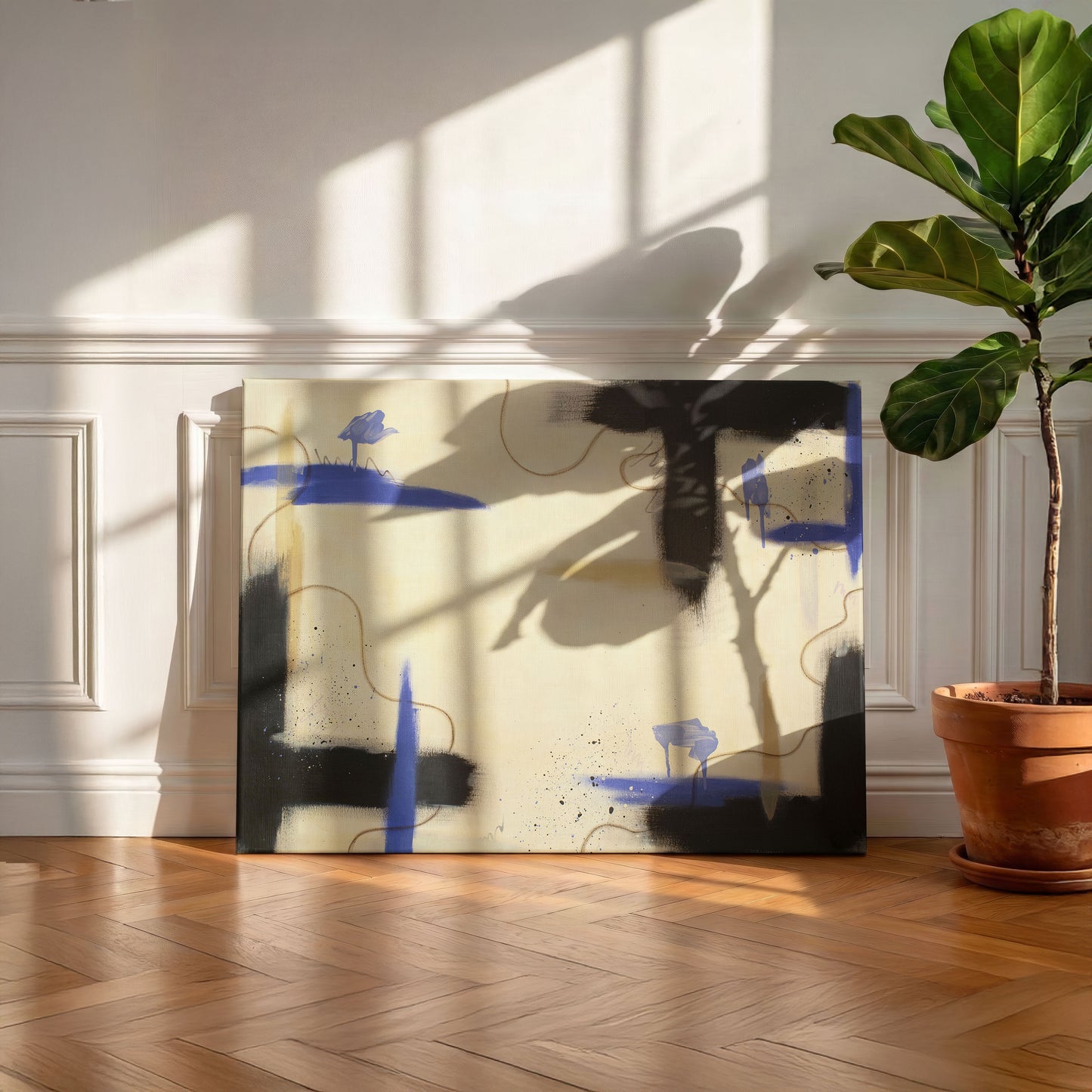A large canvas print of the painting leaning against a white wall with wainscoting, sitting on a hazelnut colored wooden floor. On the right of the canvas is a potted tree in a terracotta colored pot.
