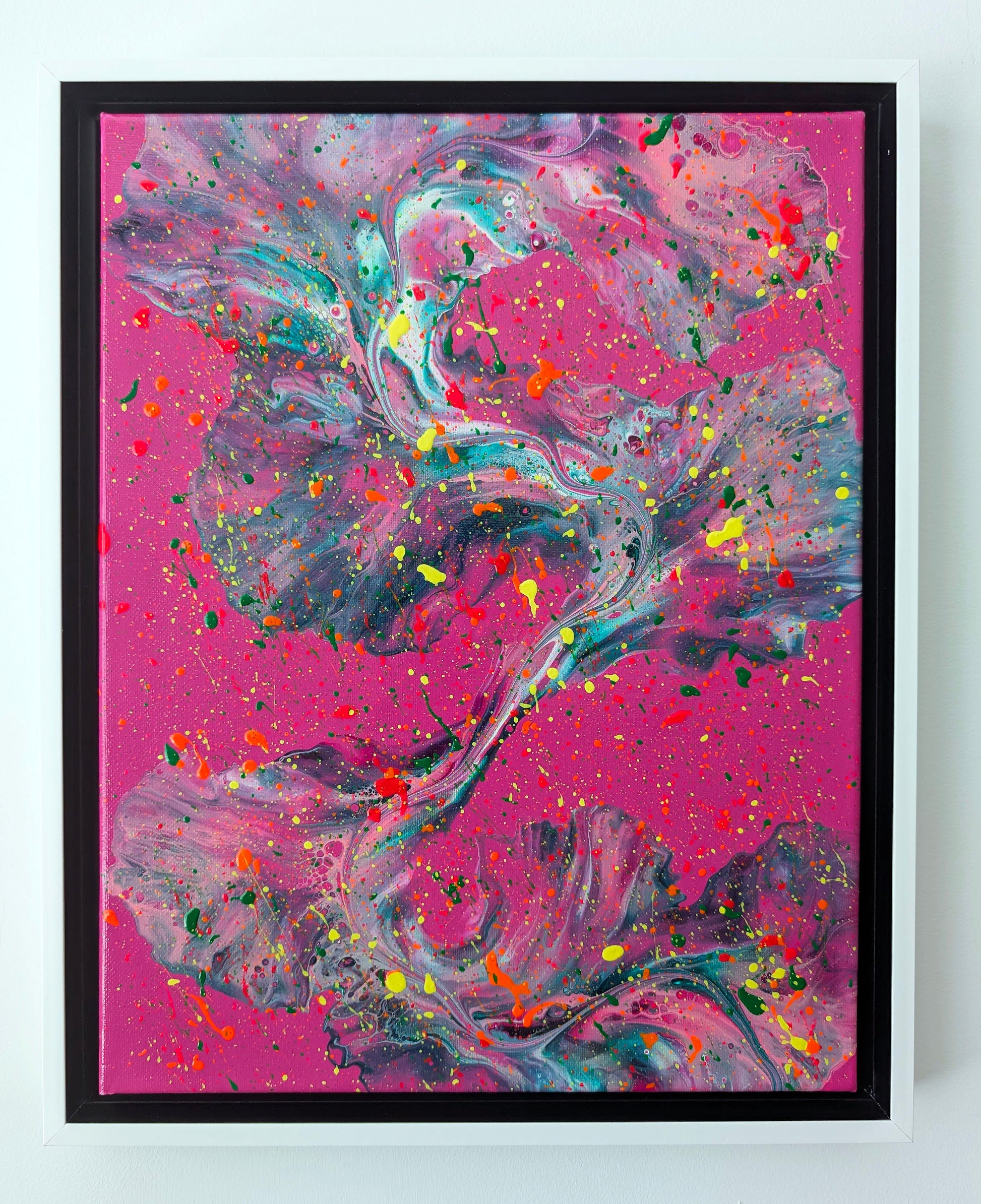 Original abstract fluid art painting titled 'That’s a Bold Choice,' featuring sweeping teal, white, and purple marbled textures over a hot pink background, layered with splashes of neon green, yellow, orange, and red. Displayed in a white floating frame against a white wall.