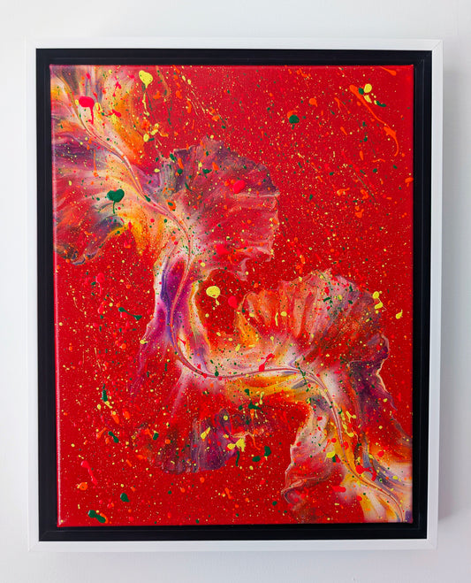 Framed acrylic fluid art painting with a bold red background and swirling shapes in purples, oranges, yellows, and greens. The splatter technique adds vibrant movement throughout the piece.