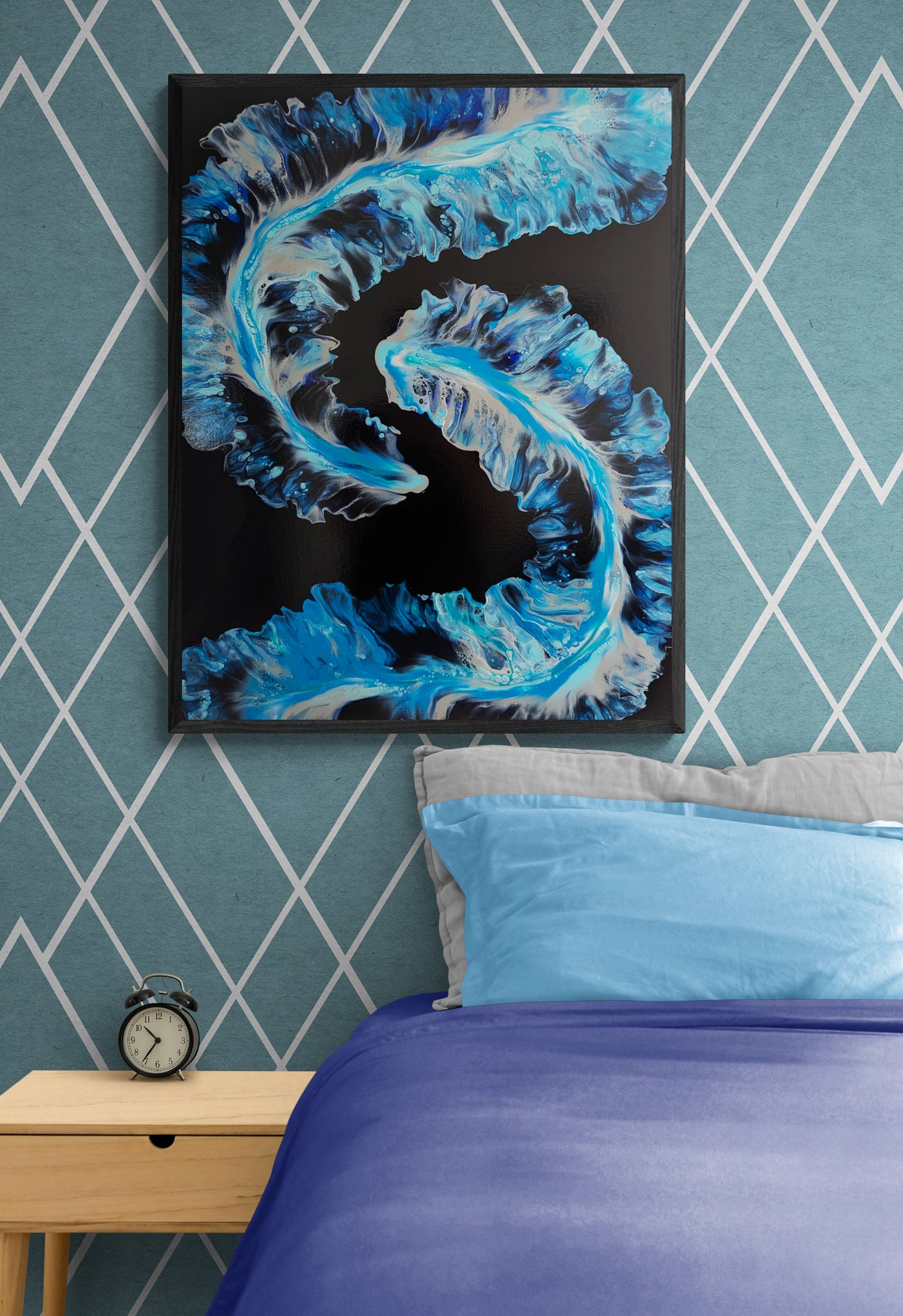 Framed painting titled “Tidal” hanging above a bed with light and dark blue bedding. The room has diamond-patterned teal wallpaper and a minimalist wooden nightstand with a black alarm clock.