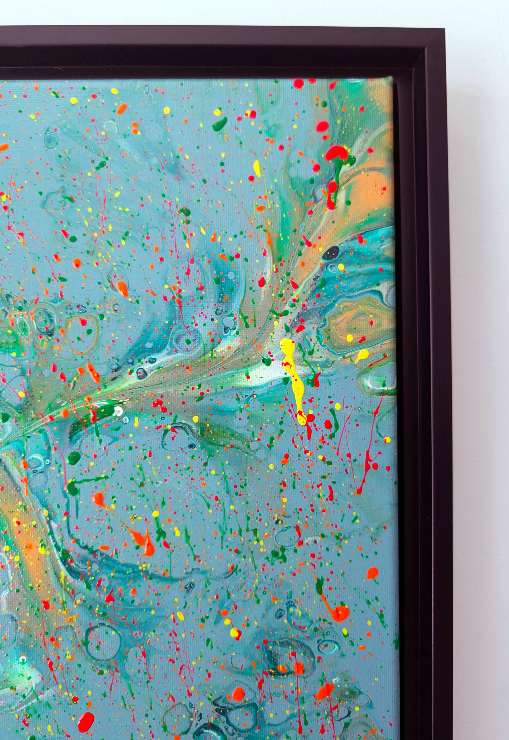 Close-up of the upper right area of the painting, highlighting flowing marbled ribbons of green, teal, and beige, intersected by energetic neon paint splatters in red, yellow, and orange.
