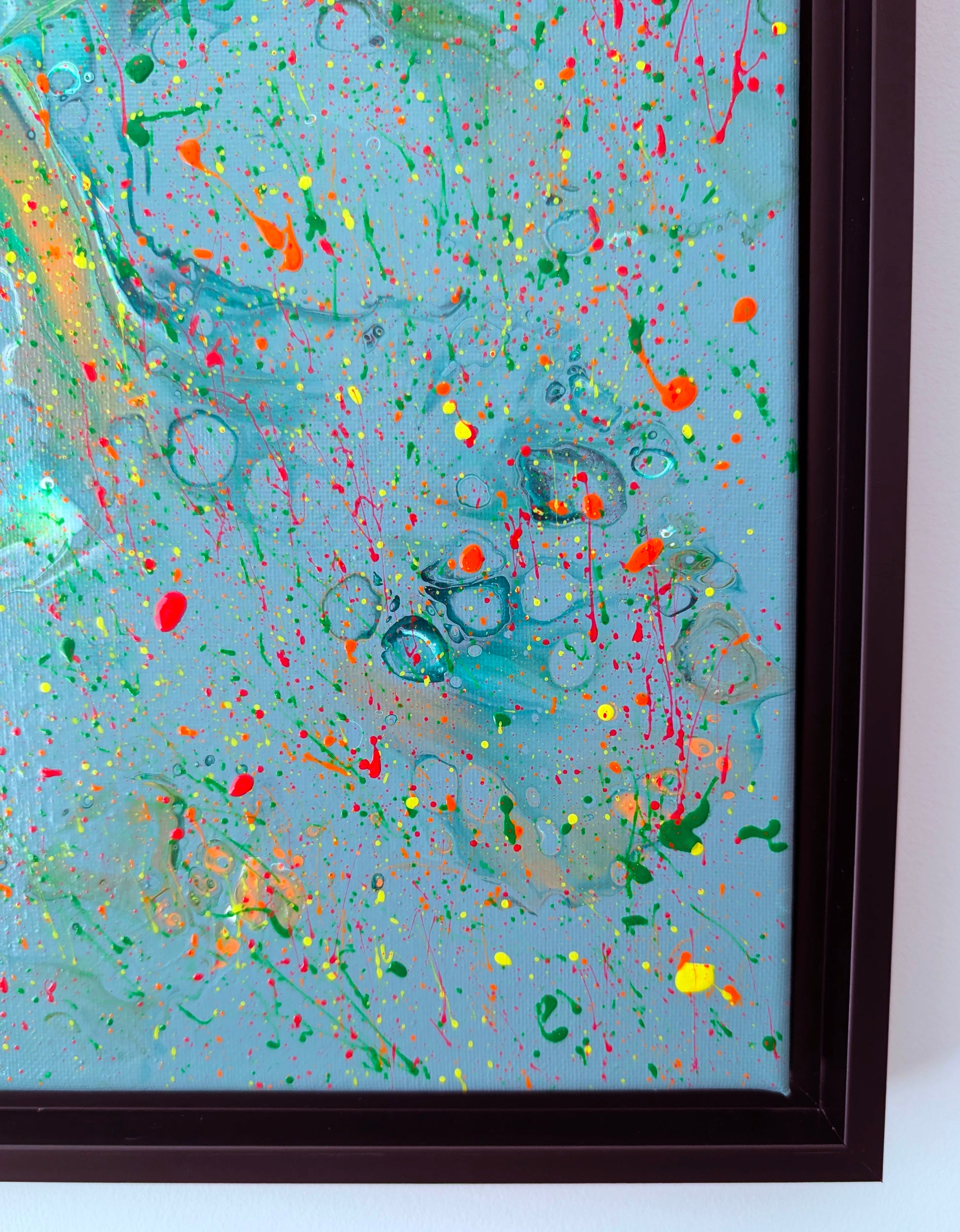 Close-up of the bottom right corner of the painting, focusing on the interplay of orange, red, yellow, and green splatters layered over soft swirling textures. Circular cell details appear throughout.