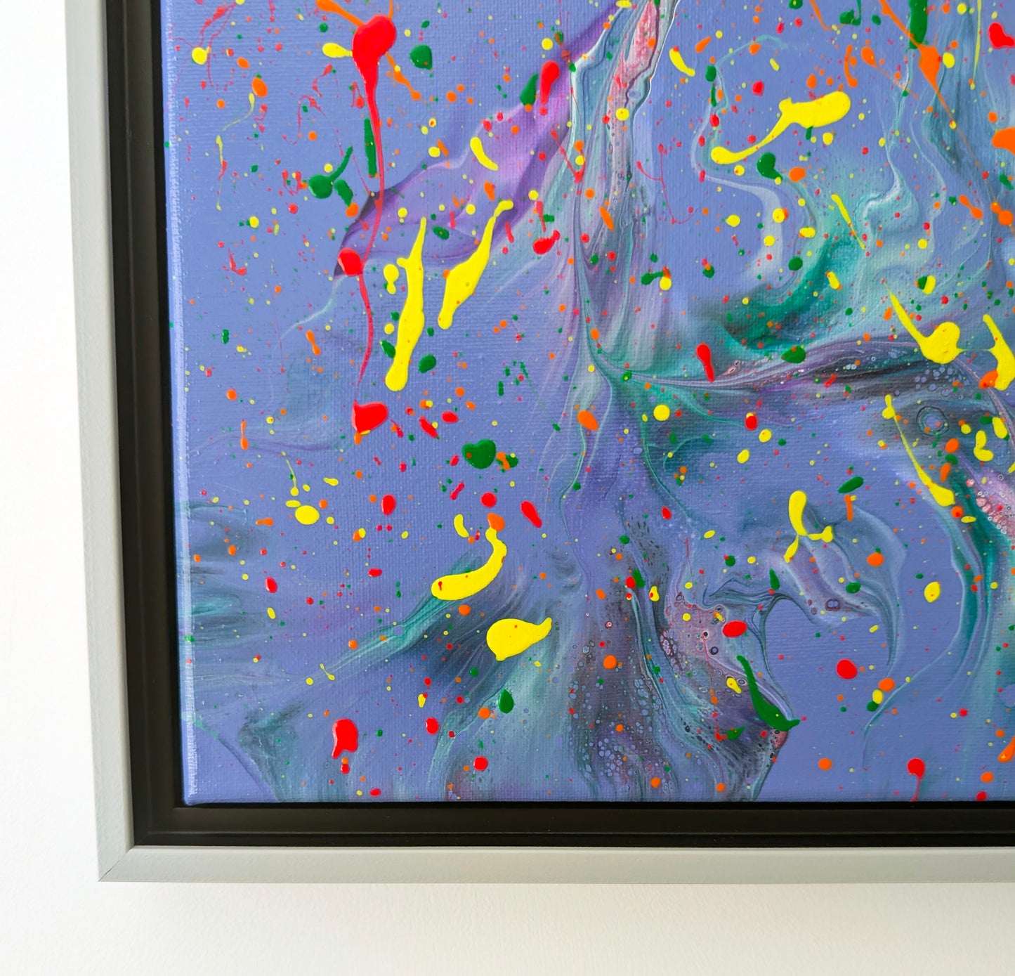 Close-up of the bottom left area of the painting, highlighting soft marbled effects in purple and teal with vibrant yellow and red splatters layered on top. Small bubbles and lacing add textural interest.