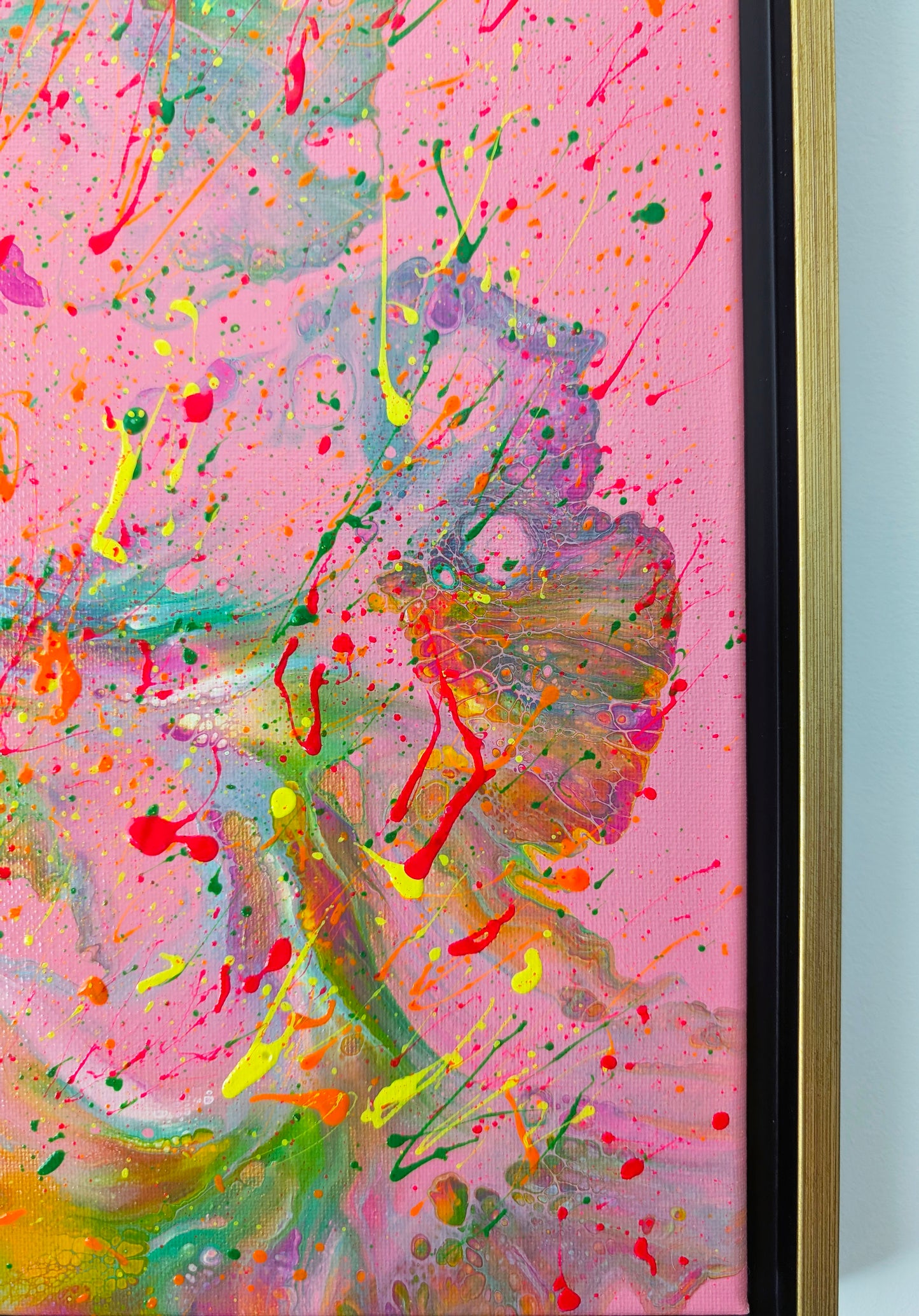 Close-up of the right side of the painting, showing intricate marbled waves of orange, green, and purple blending into the pink background. Neon splatters in yellow, red, and green are scattered throughout.